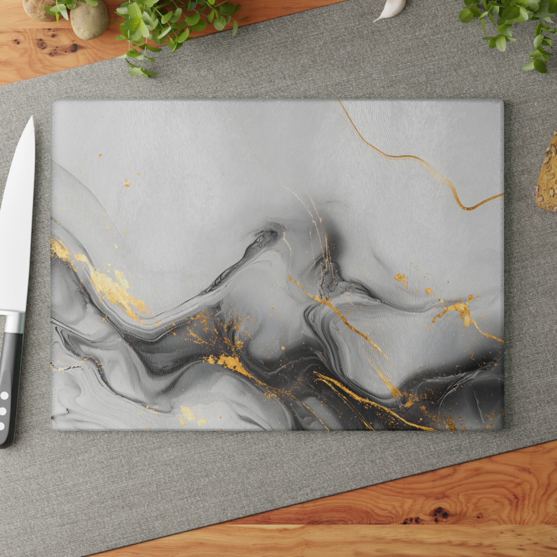 Marble-patterned cutting board with gold accents on a gray surface next to a knife.