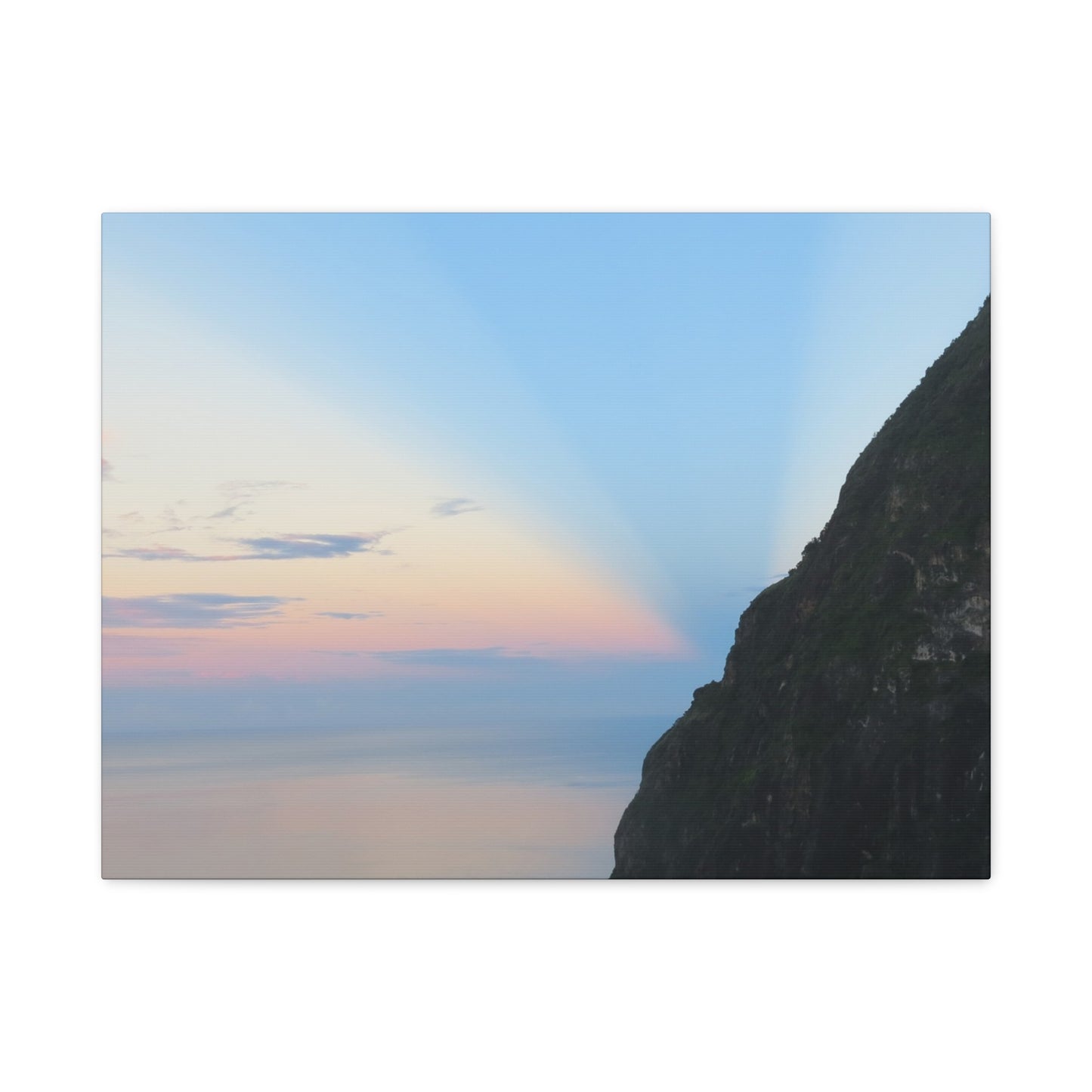 Mountain silhouette against a colorful sky with hues of blue, pink, and purple.