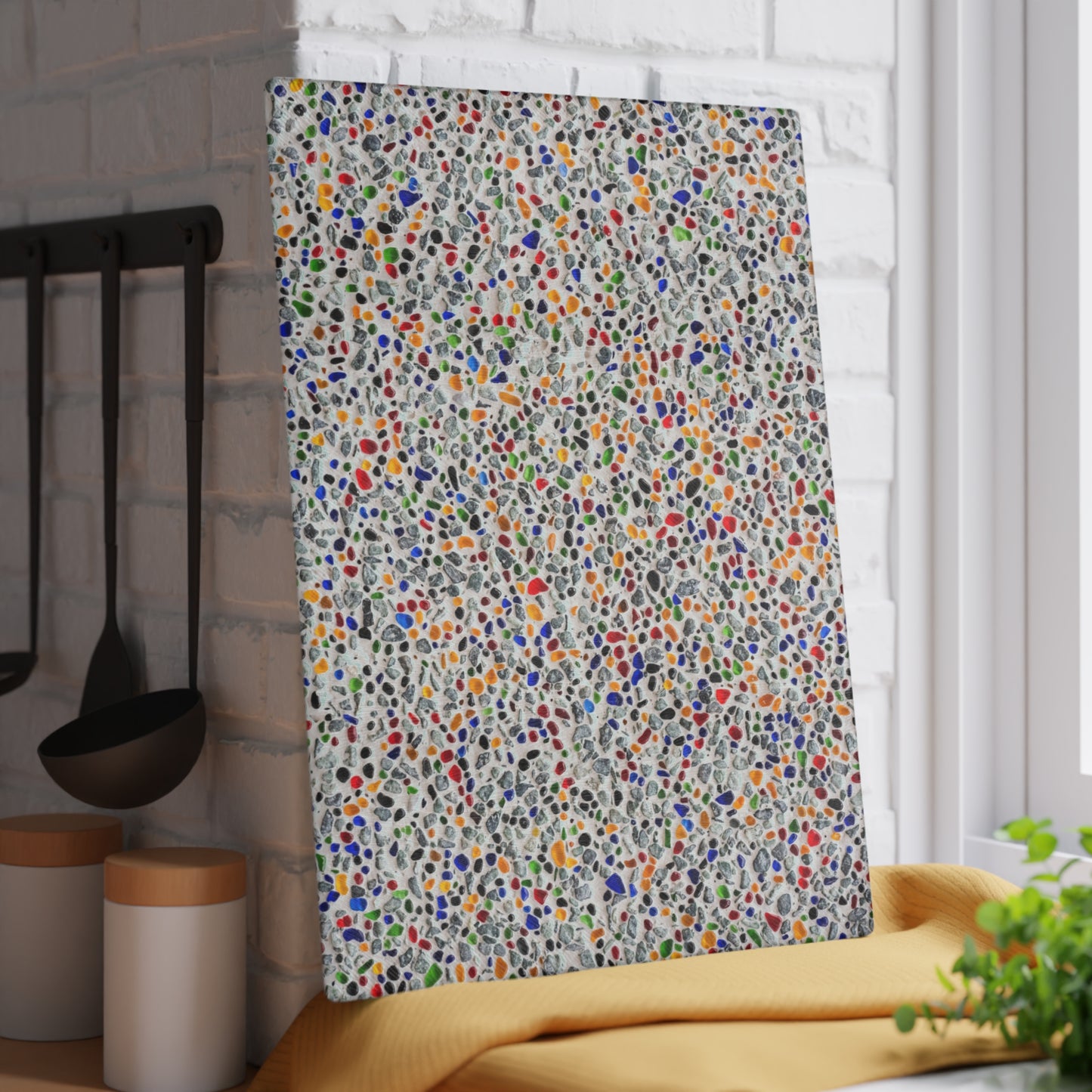 Colorful patterned towel hanging on a rack in a kitchen setting.