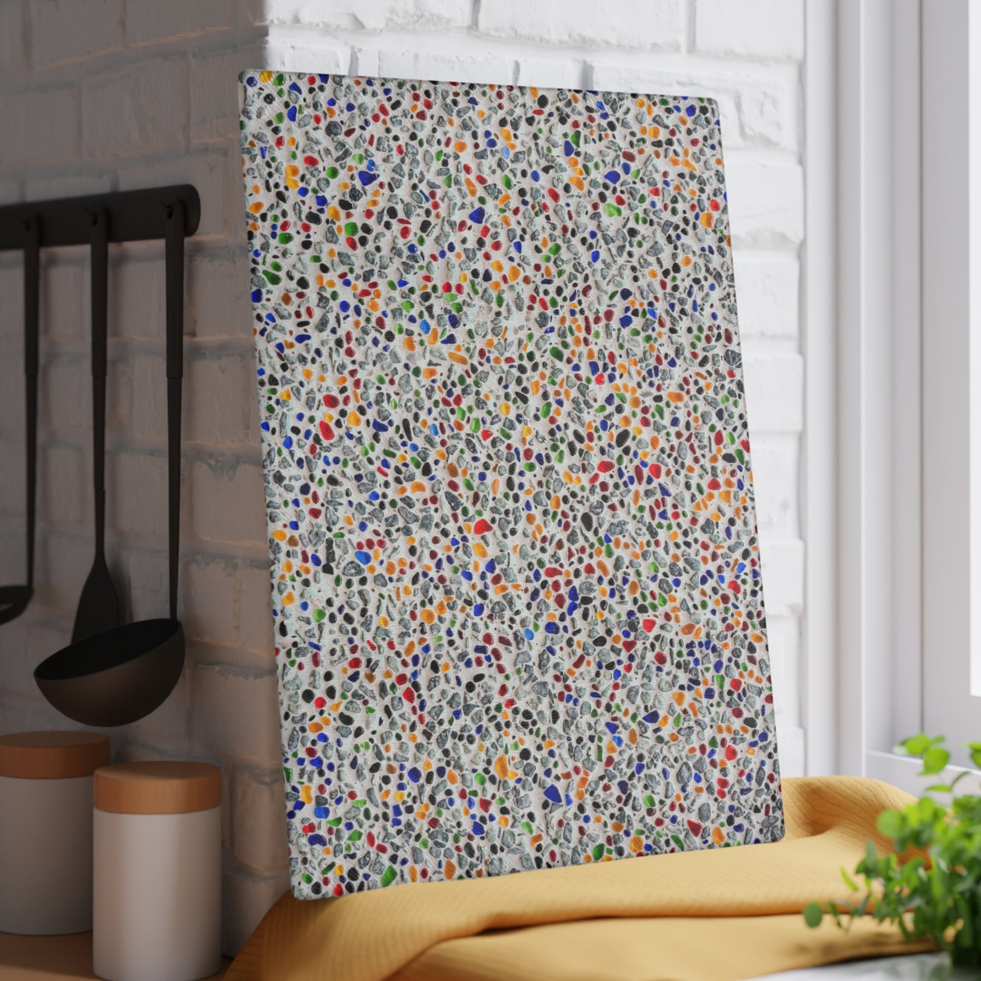 Colorful patterned towel hanging on a rack in a kitchen setting.