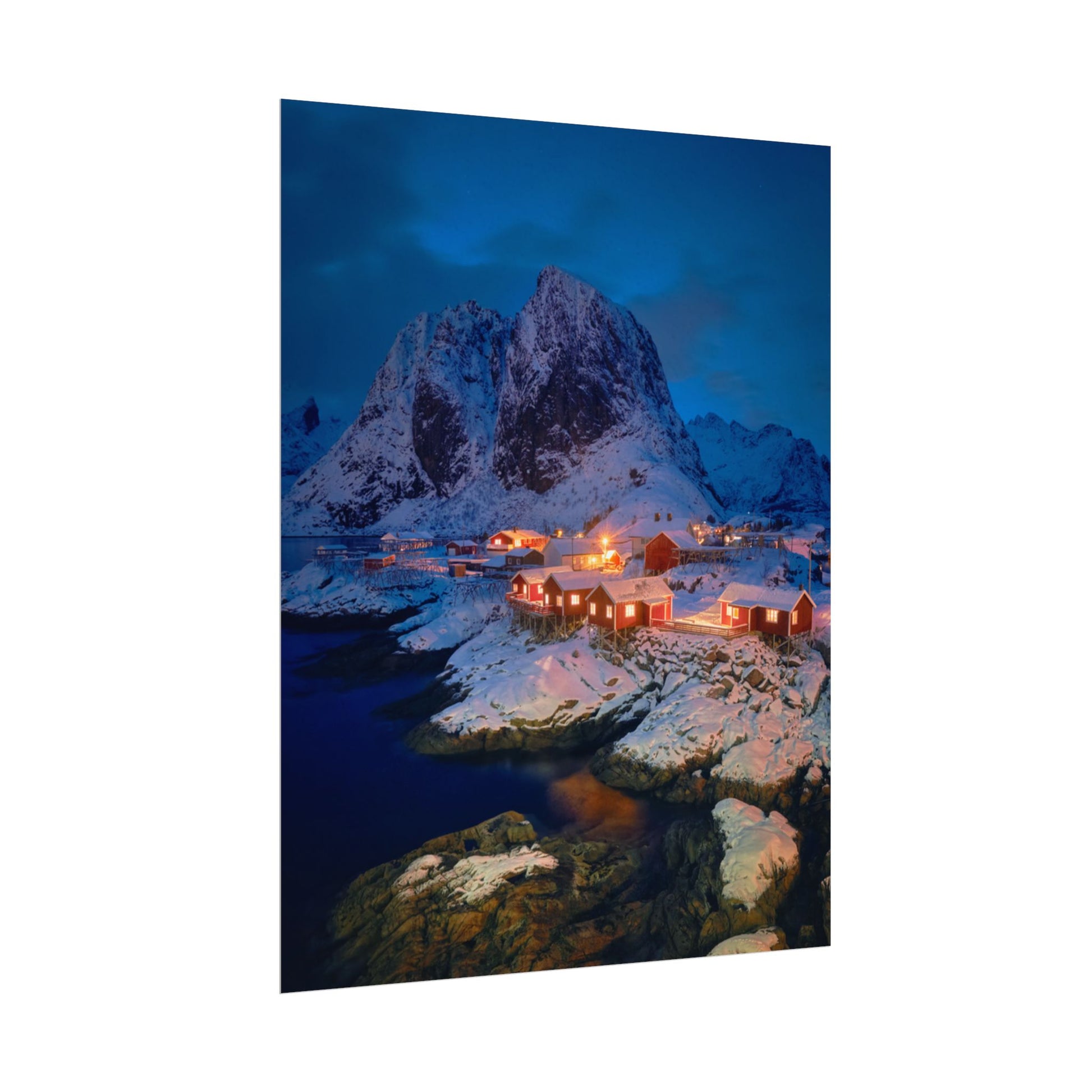 Framed photograph of a snowy mountain landscape with illuminated buildings.