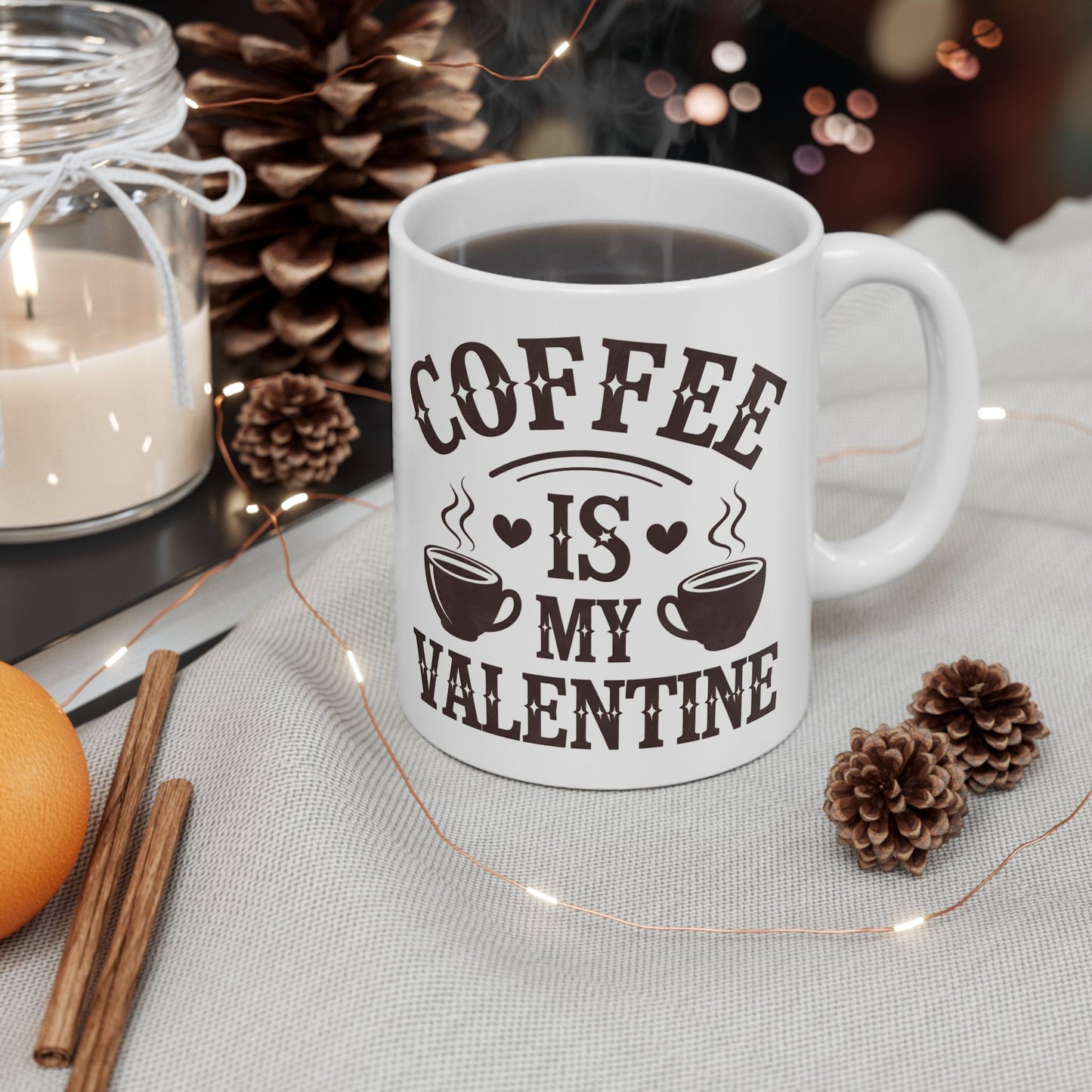 White mug with 'Coffee is my Valentine' text on a table with decorative items.