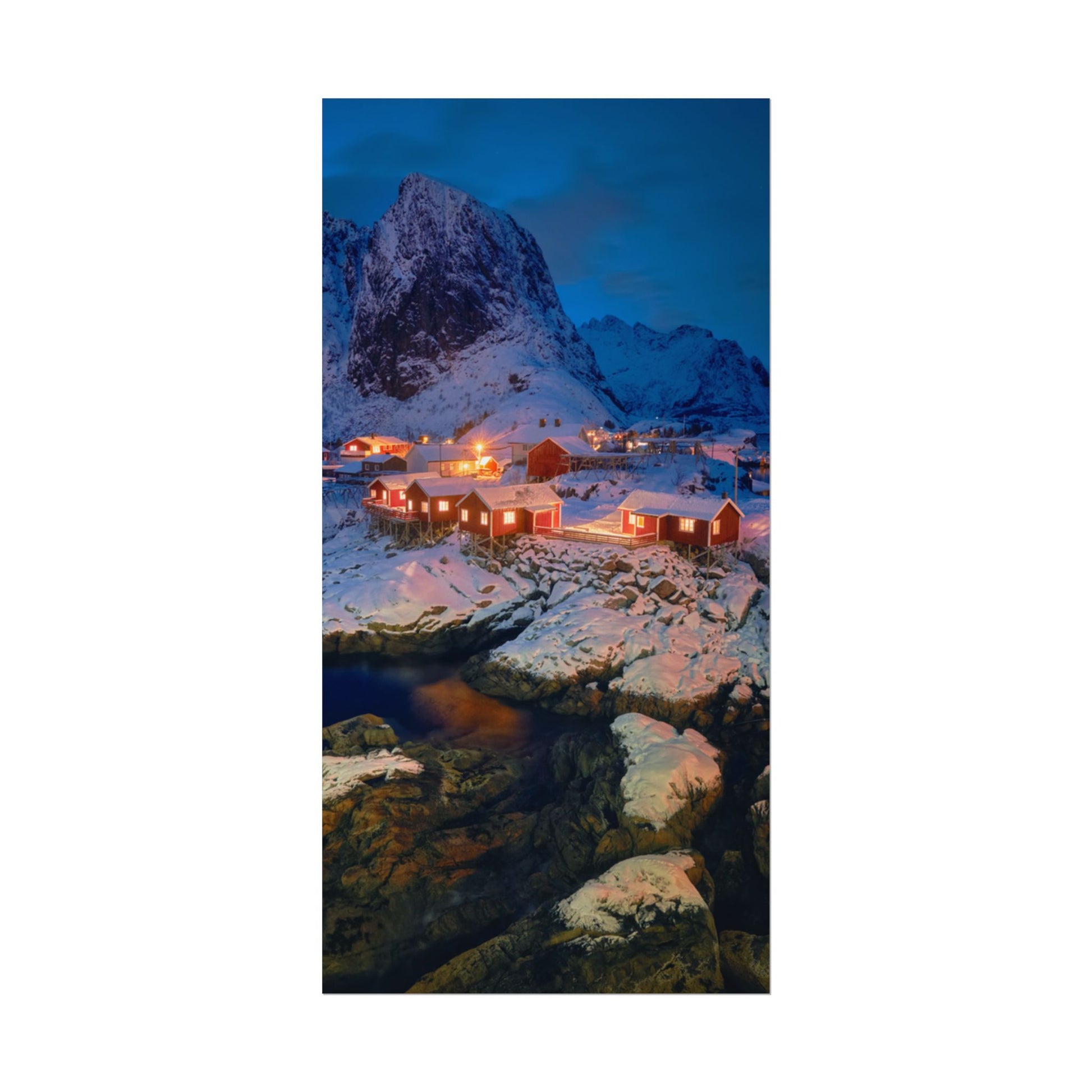 Snowy mountain landscape with illuminated buildings at night