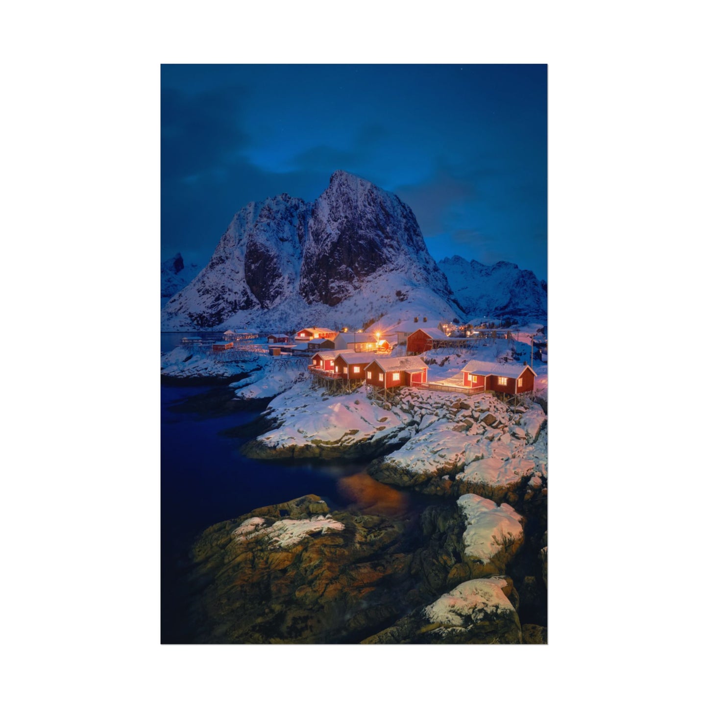 Snowy mountain landscape with illuminated buildings at night