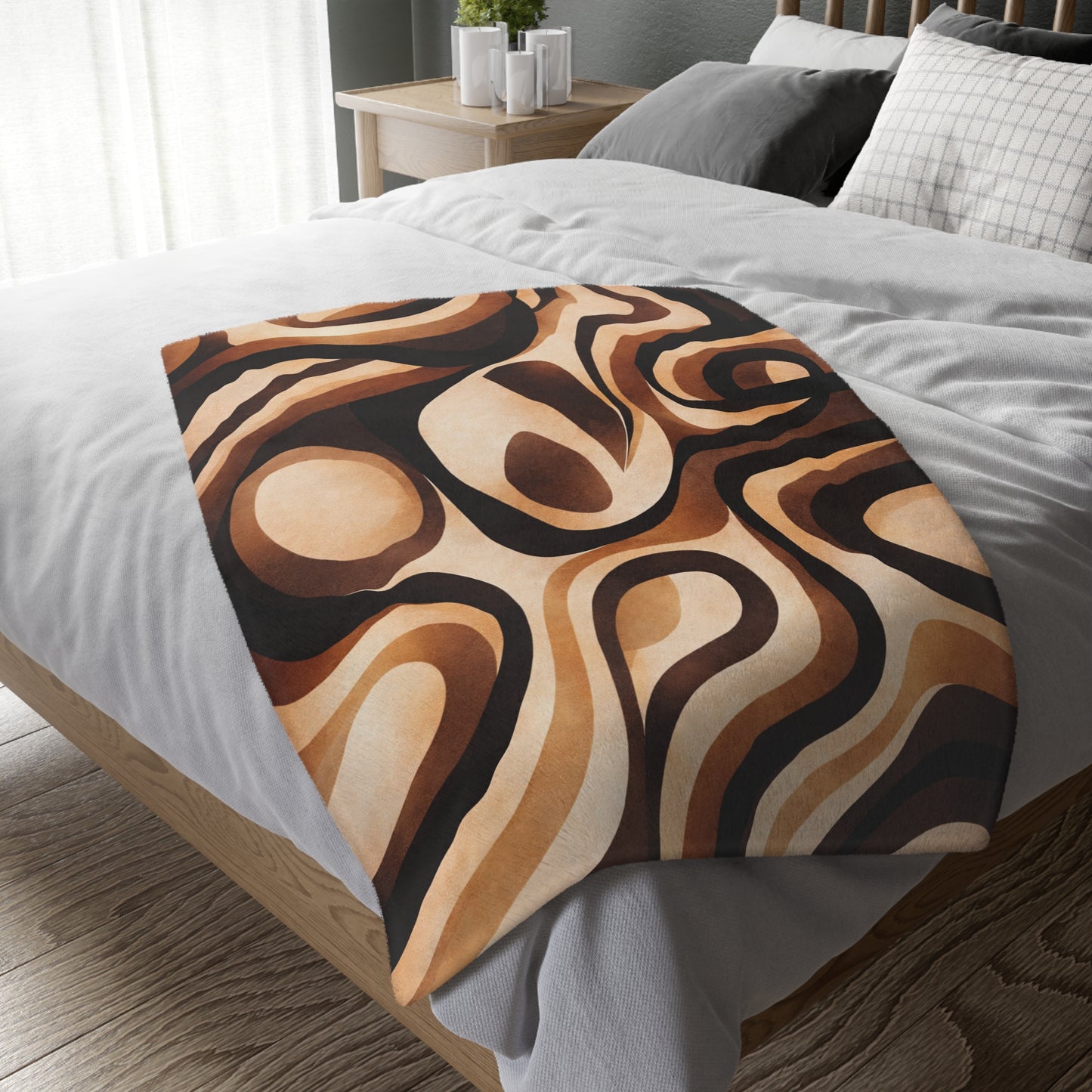 Decorative throw blanket with brown abstract pattern on a bed in a bedroom setting.