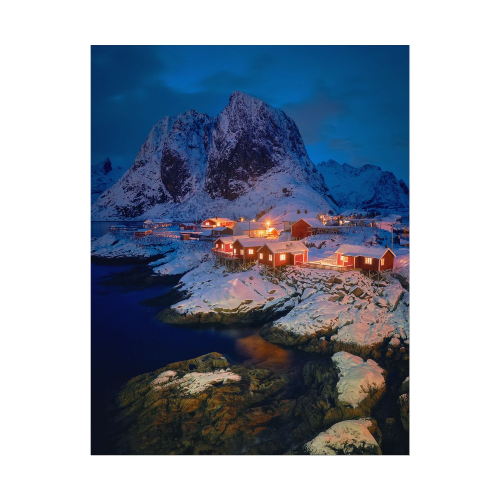 Snowy mountain landscape with illuminated buildings at night