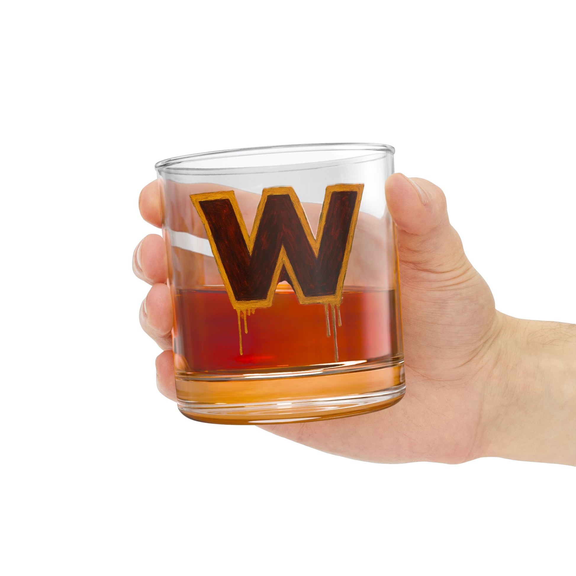 Hand holding a glass with a letter 'W' design filled with a red liquid on a white background