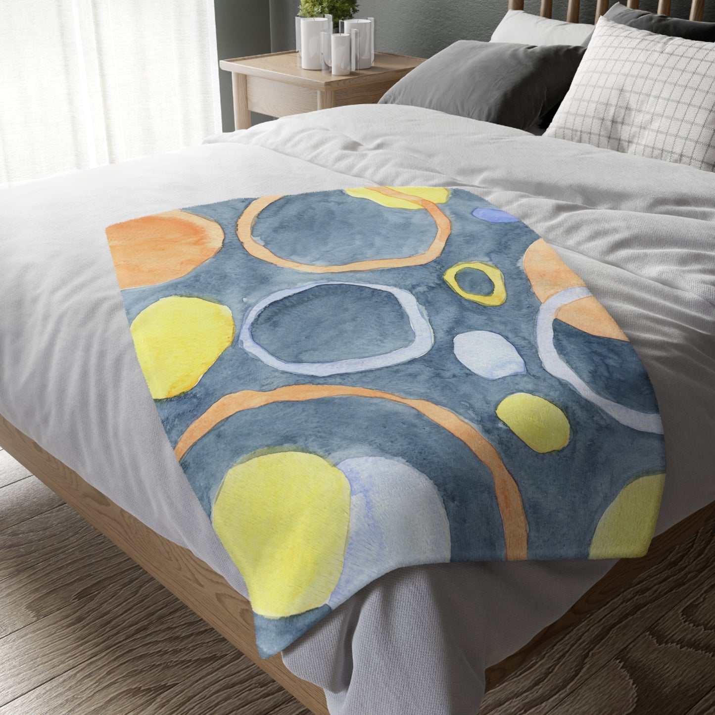 Colorful abstract patterned blanket on a bed in a bedroom setting