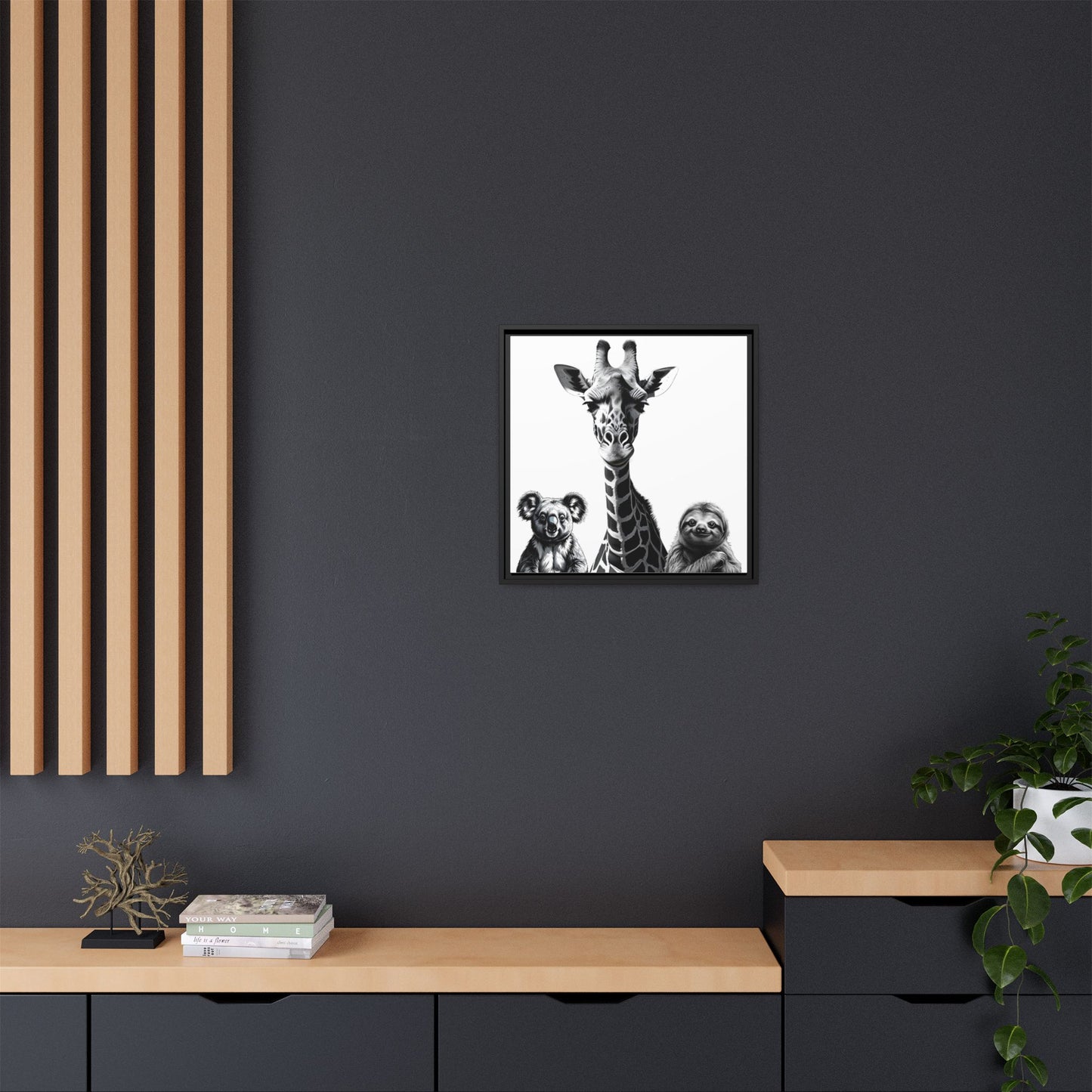Framed artwork of a giraffe and sloth on a dark wall above a wooden shelf.
