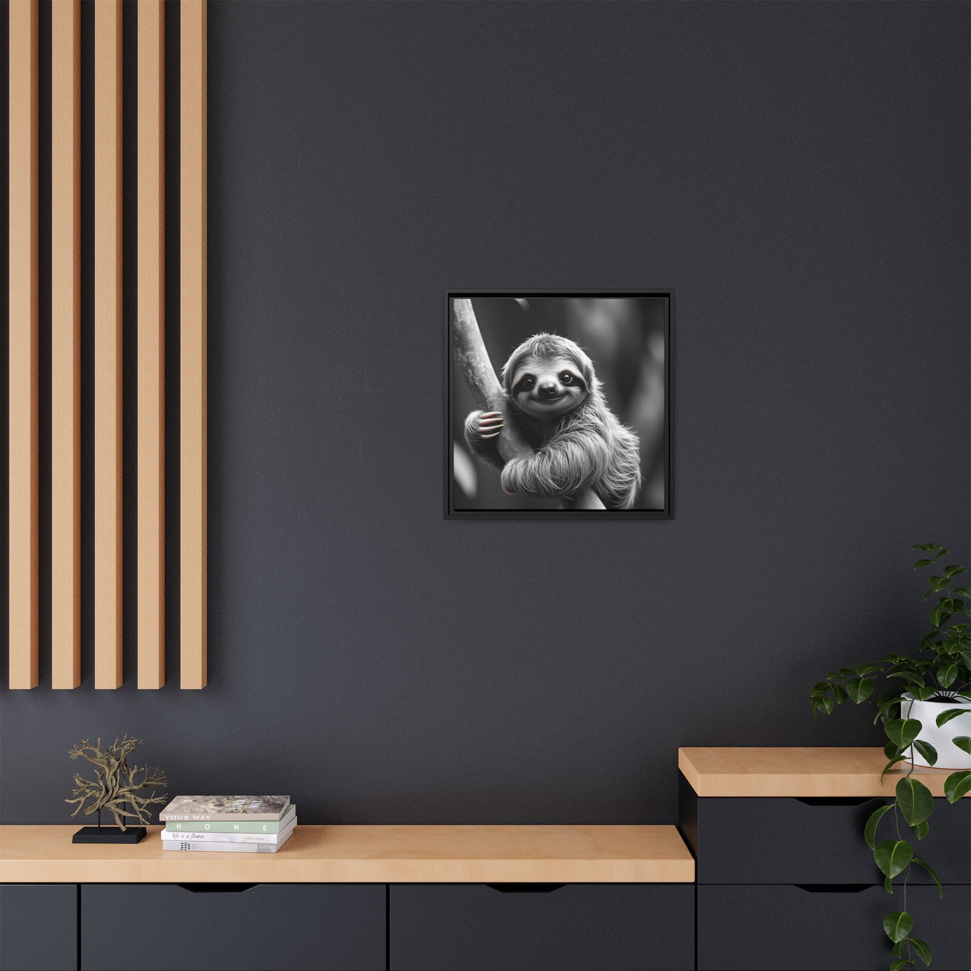 Framed black and white sloth print on a dark wall with wooden shelves and decor.