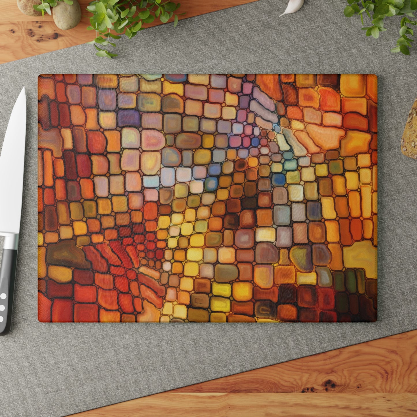 Colorful mosaic cutting board on a gray surface with a knife