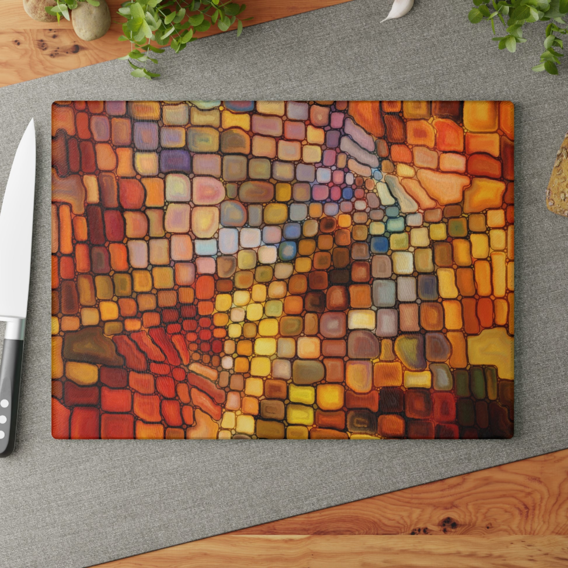 Colorful mosaic cutting board on a gray surface with a knife