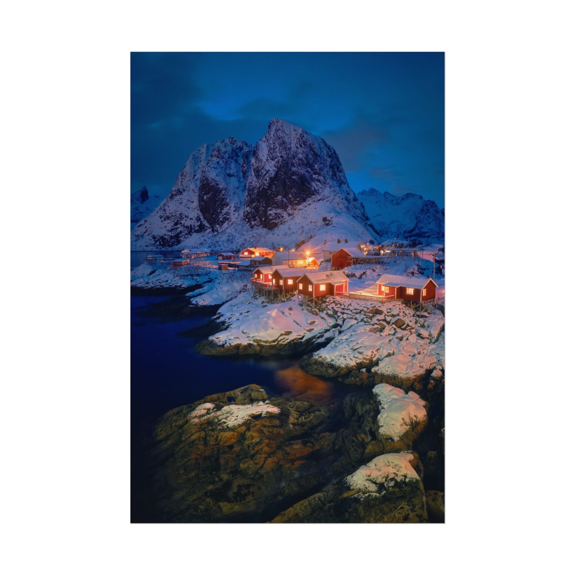 Snowy mountain landscape with illuminated buildings at night