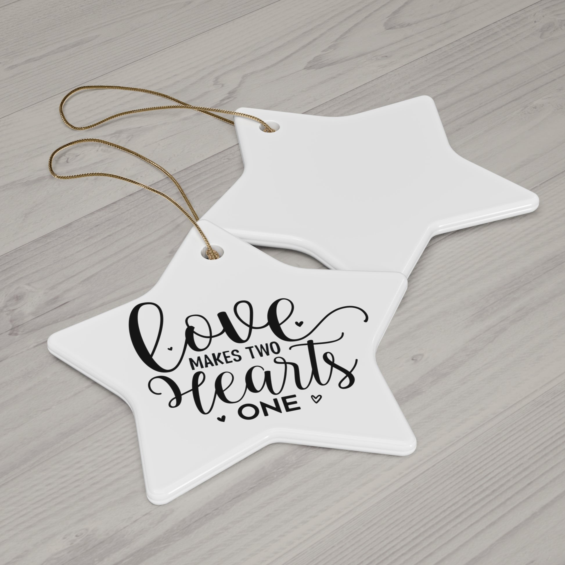 Star-shaped ceramic ornament with 'Love makes two hearts one' text on a wooden surface