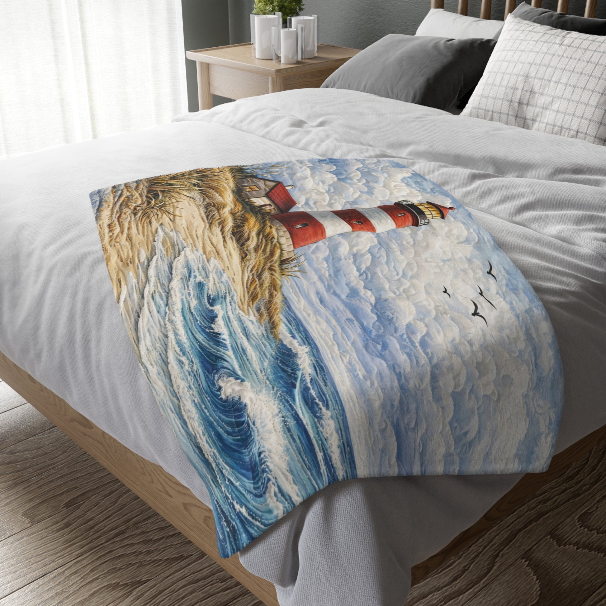 Decorative blanket with a lighthouse design on a bed in a bedroom.