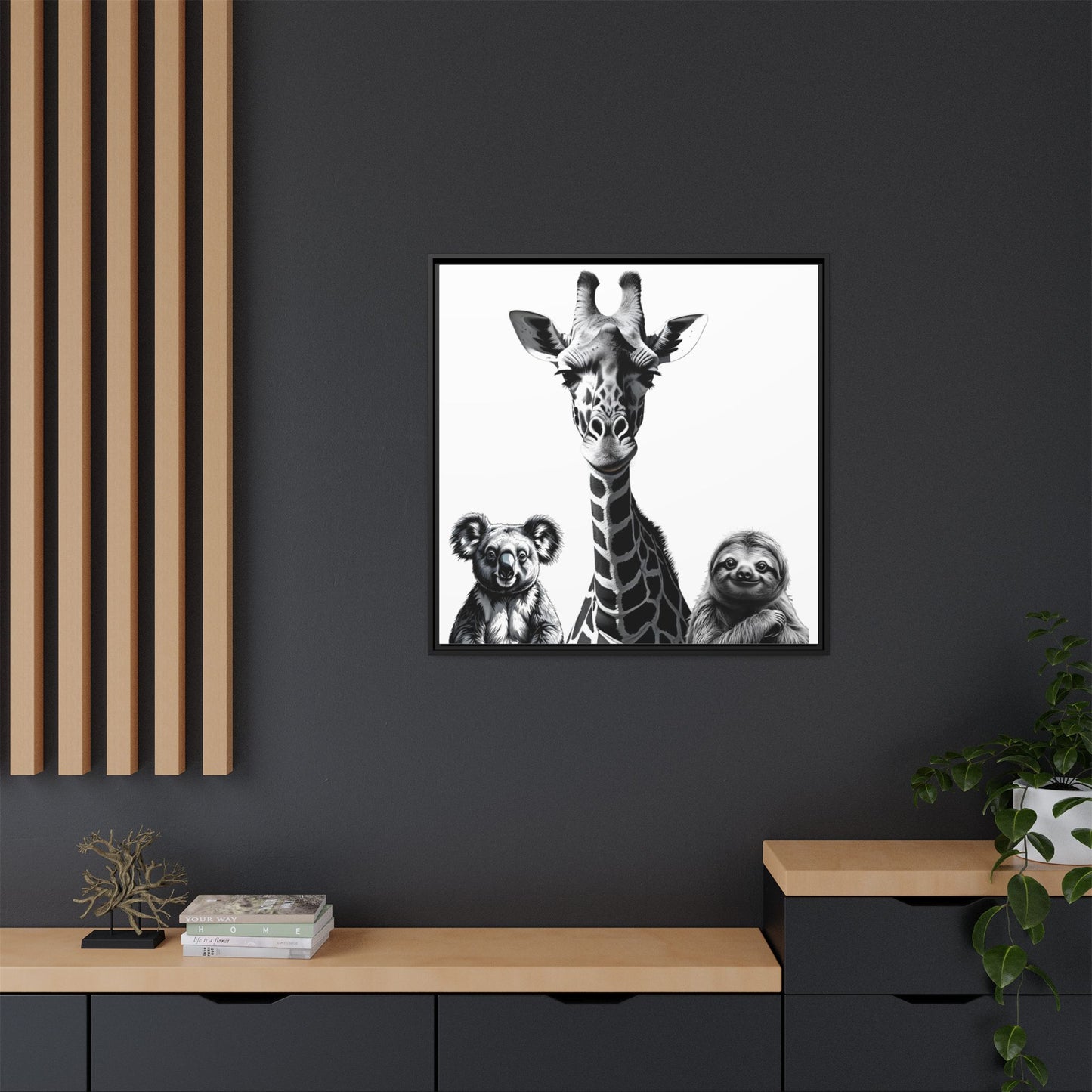 Framed artwork of a giraffe and two sloths on a dark wall with wooden shelves.