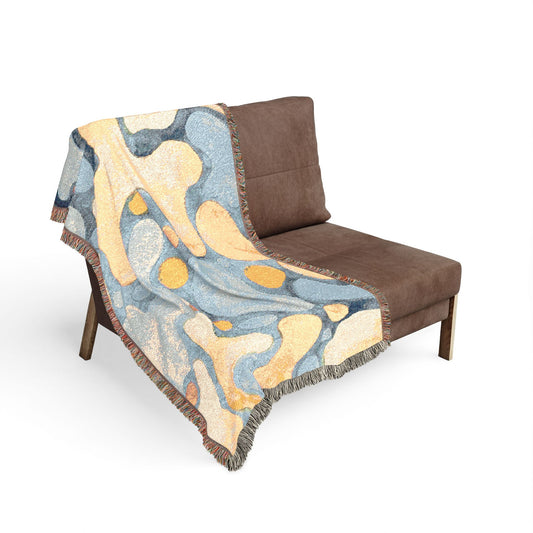 Brown chair with a colorful abstract patterned throw blanket on a white background