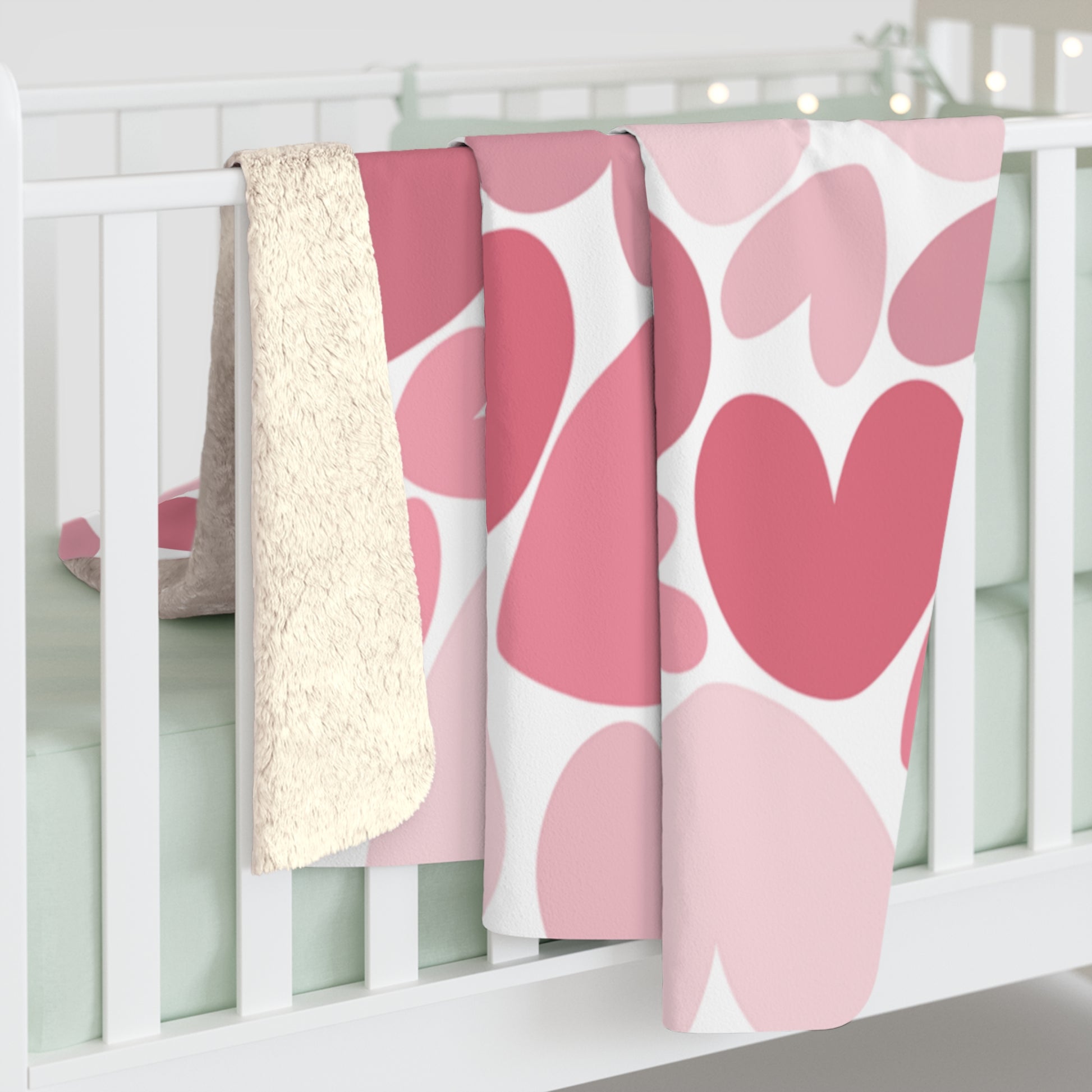 Pink and white patterned baby blankets on a crib