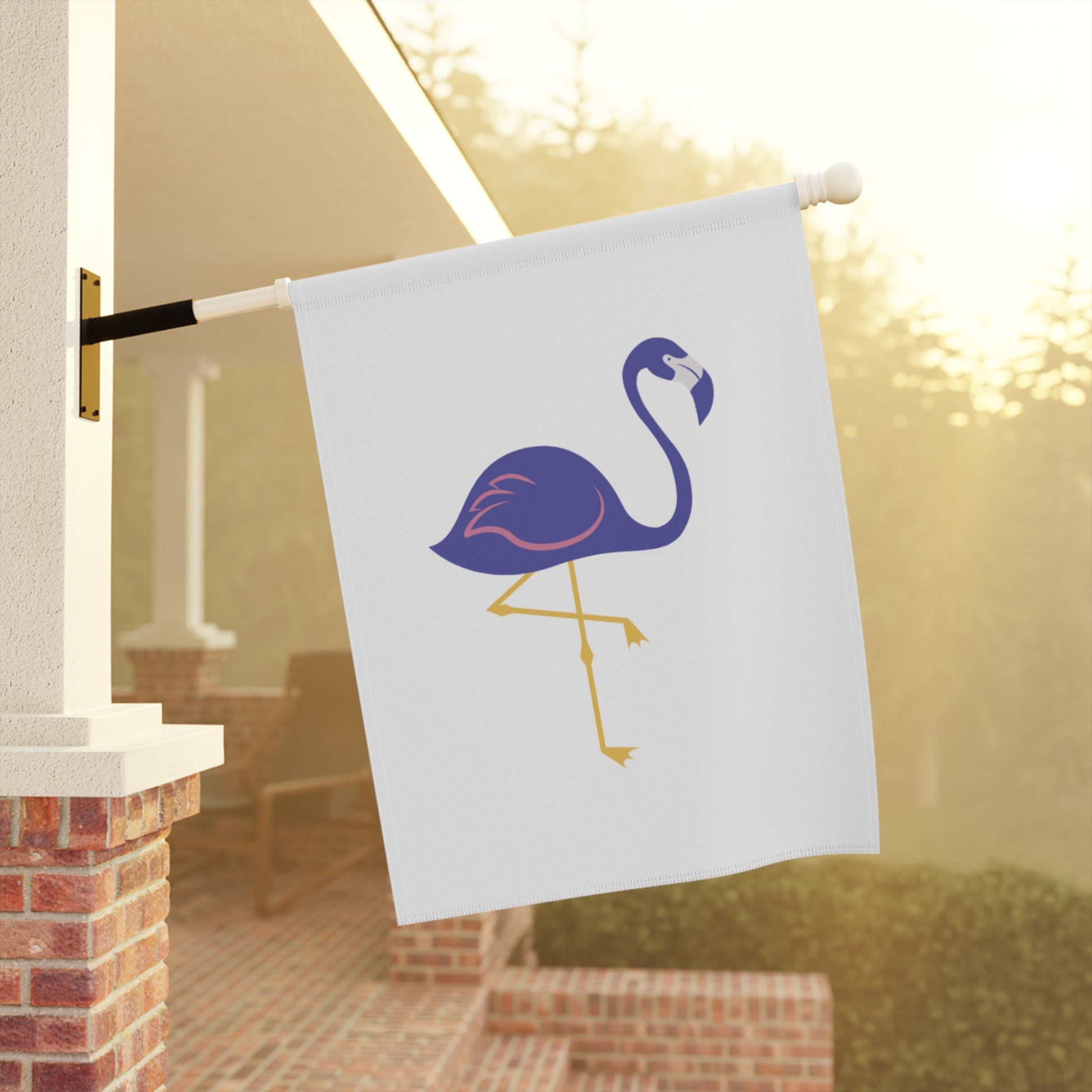 Flamingo-themed garden flag on a pole against a blurred outdoor background