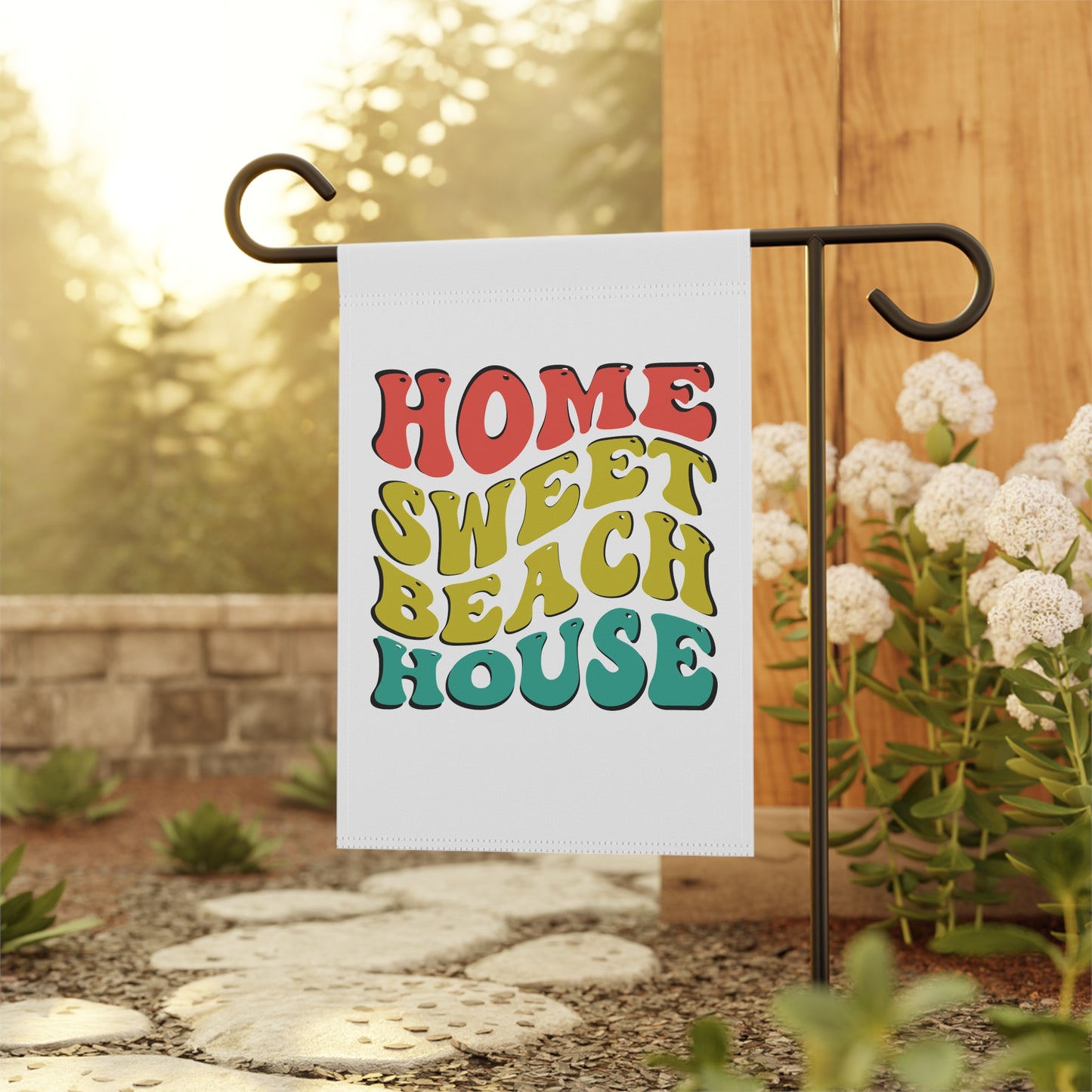 Garden flag with 'Home Sweet Beach House' text on a stand outdoors.