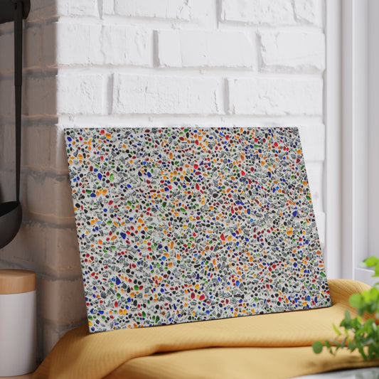 Colorful abstract patterned wall art leaning against a white brick wall.