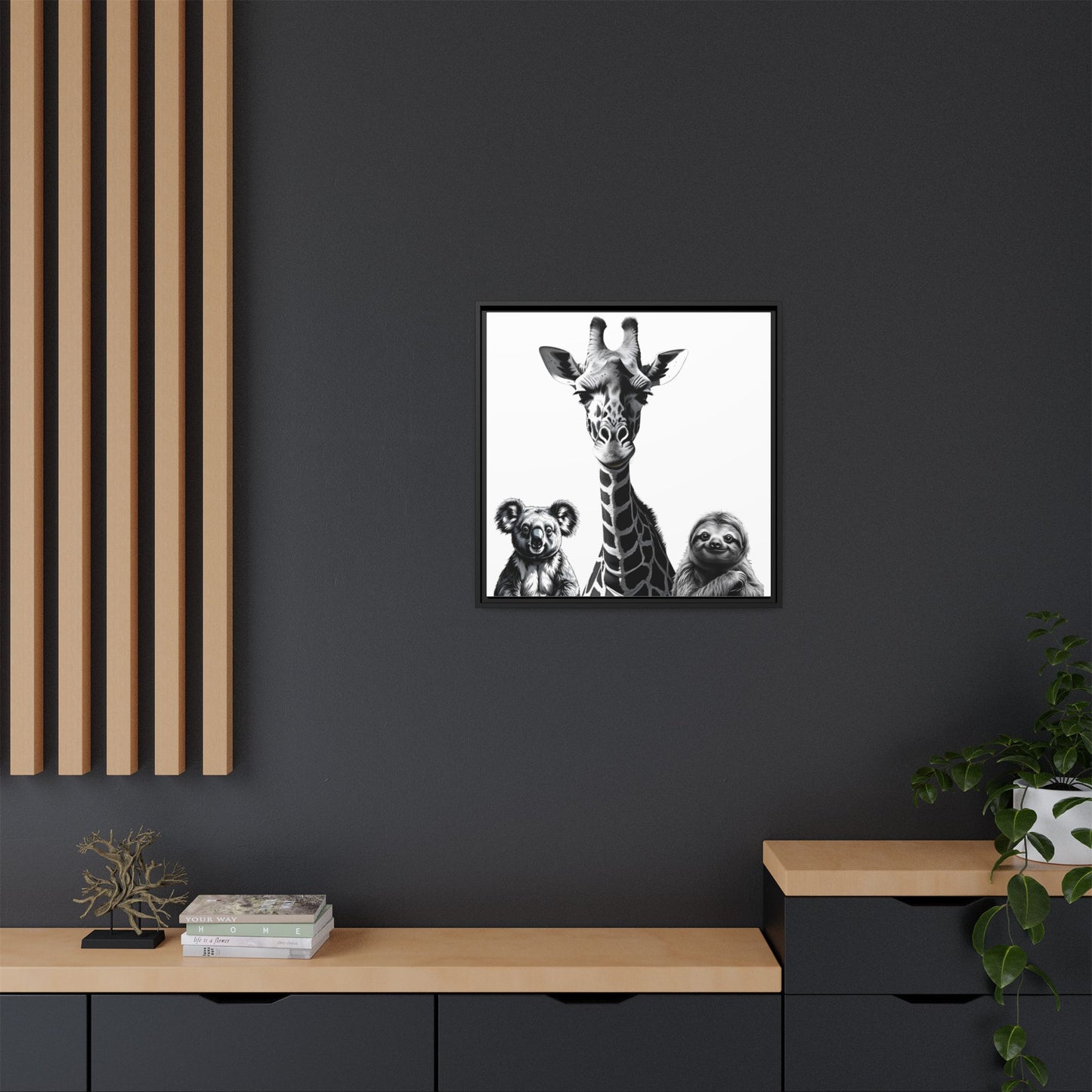 Framed artwork of a giraffe and two sloths on a dark wall with wooden shelves.