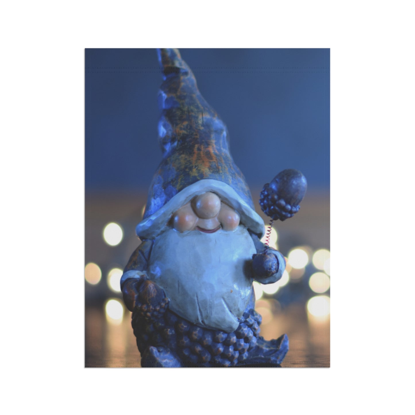 Decorative gnome figure with a blue hat and beard against a blurred light background