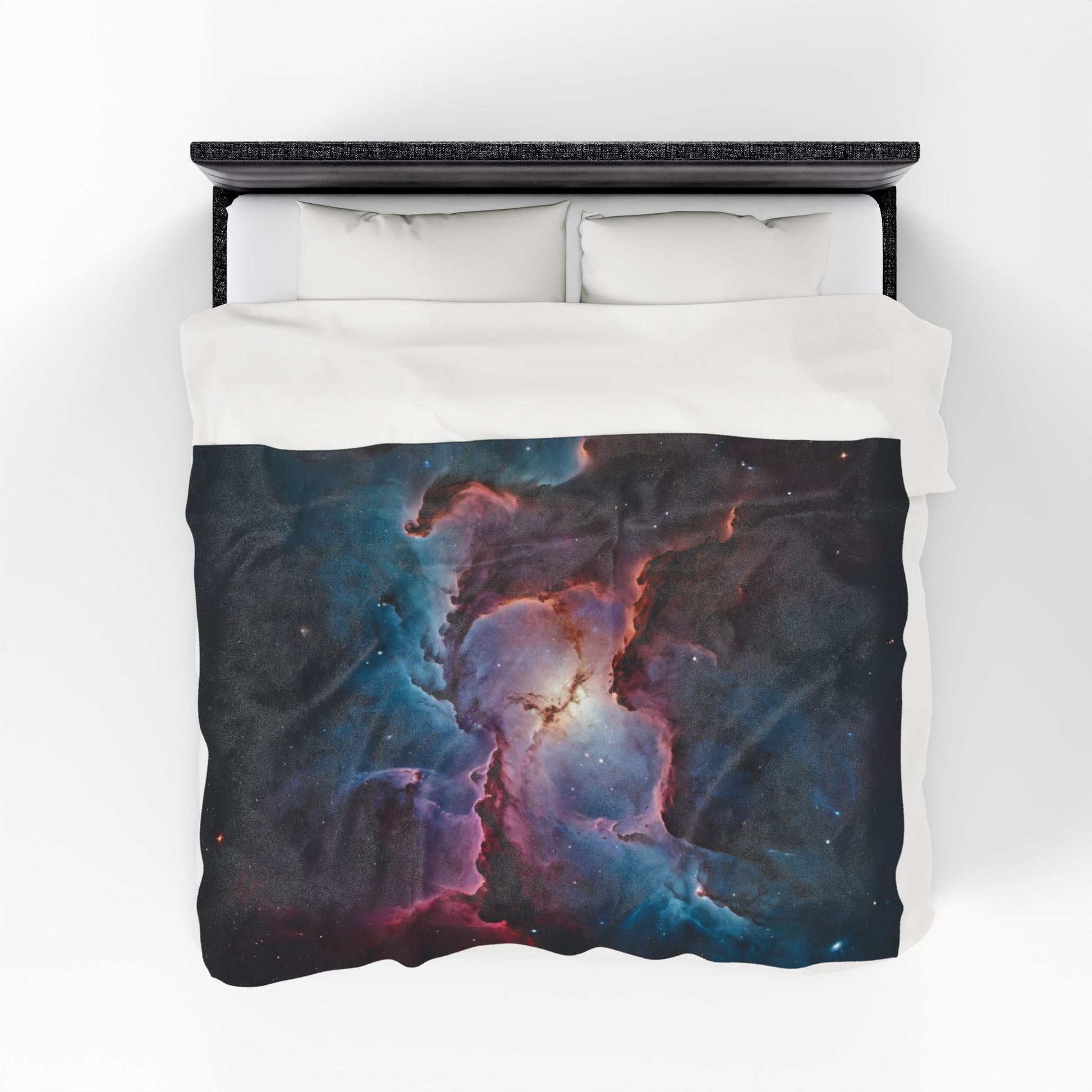 Bed with a nebula-themed comforter on a white background