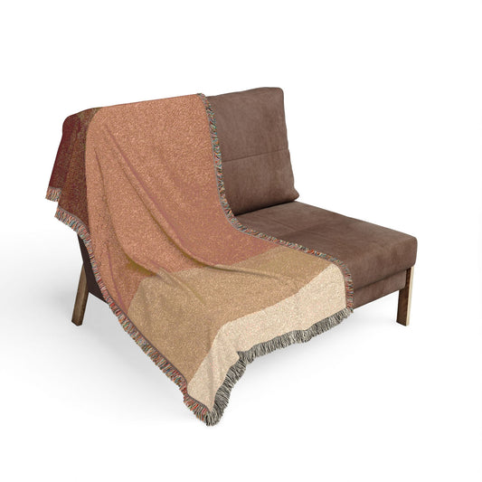 Brown and beige patterned throw blanket draped over a brown chair on a white background