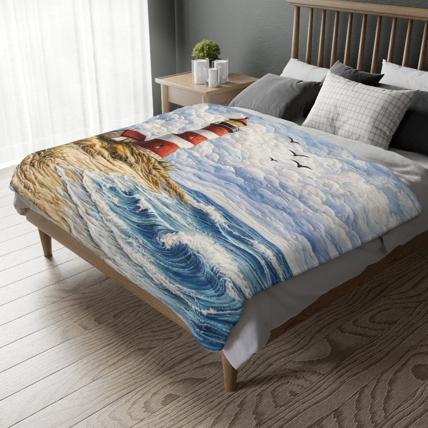 Bed with a scenic blanket featuring a lighthouse and ocean waves.