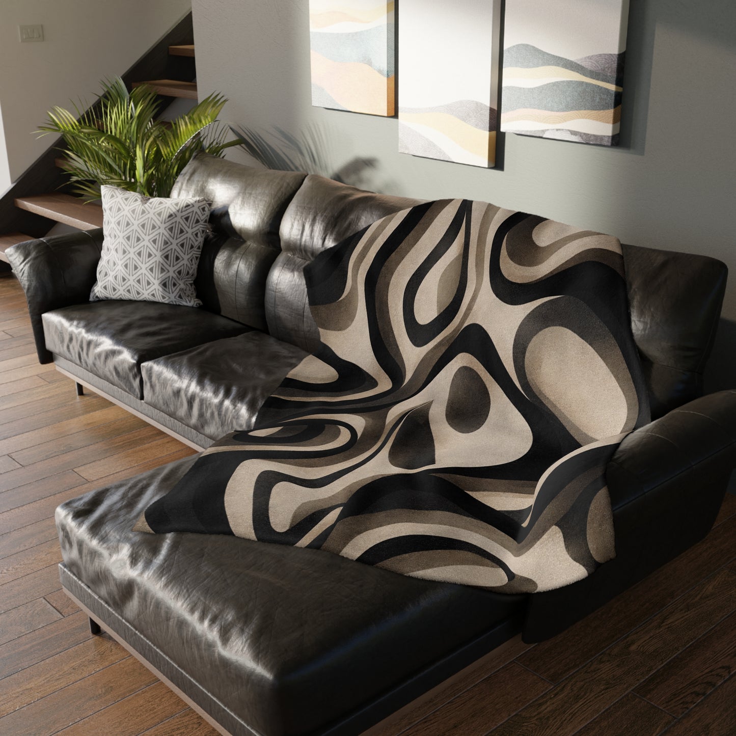 Brown leather sofa with a patterned throw blanket in a living room setting.