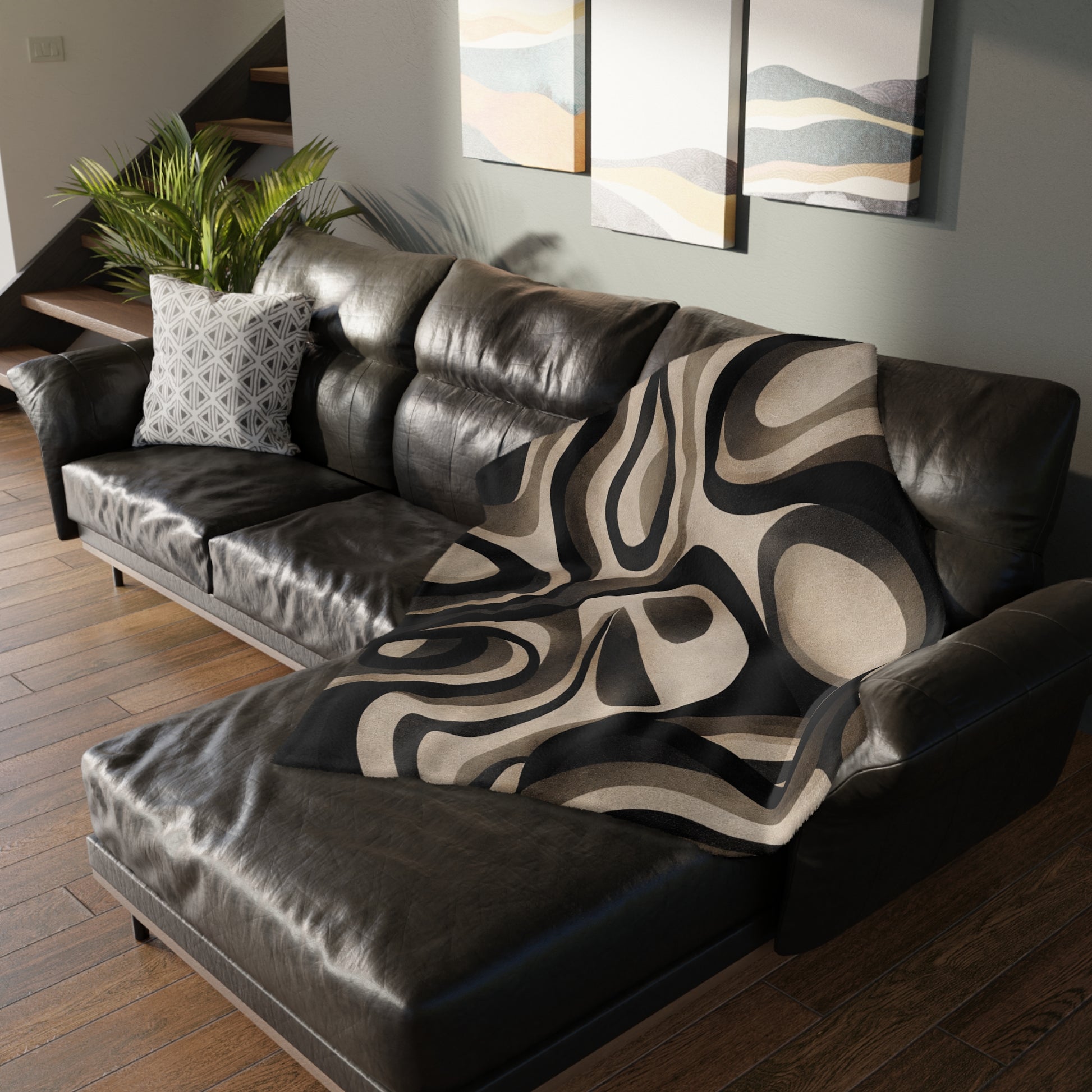 Brown leather sectional sofa with a patterned throw blanket in a living room setting.