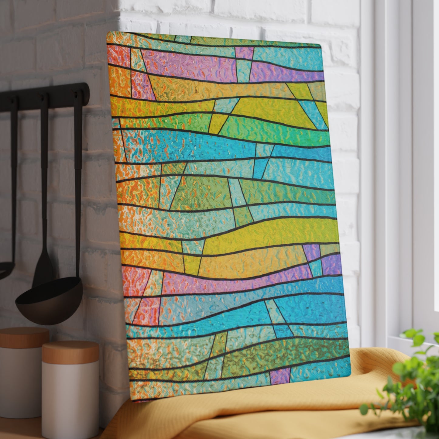 Colorful abstract patterned towel hanging on a rack in a kitchen.