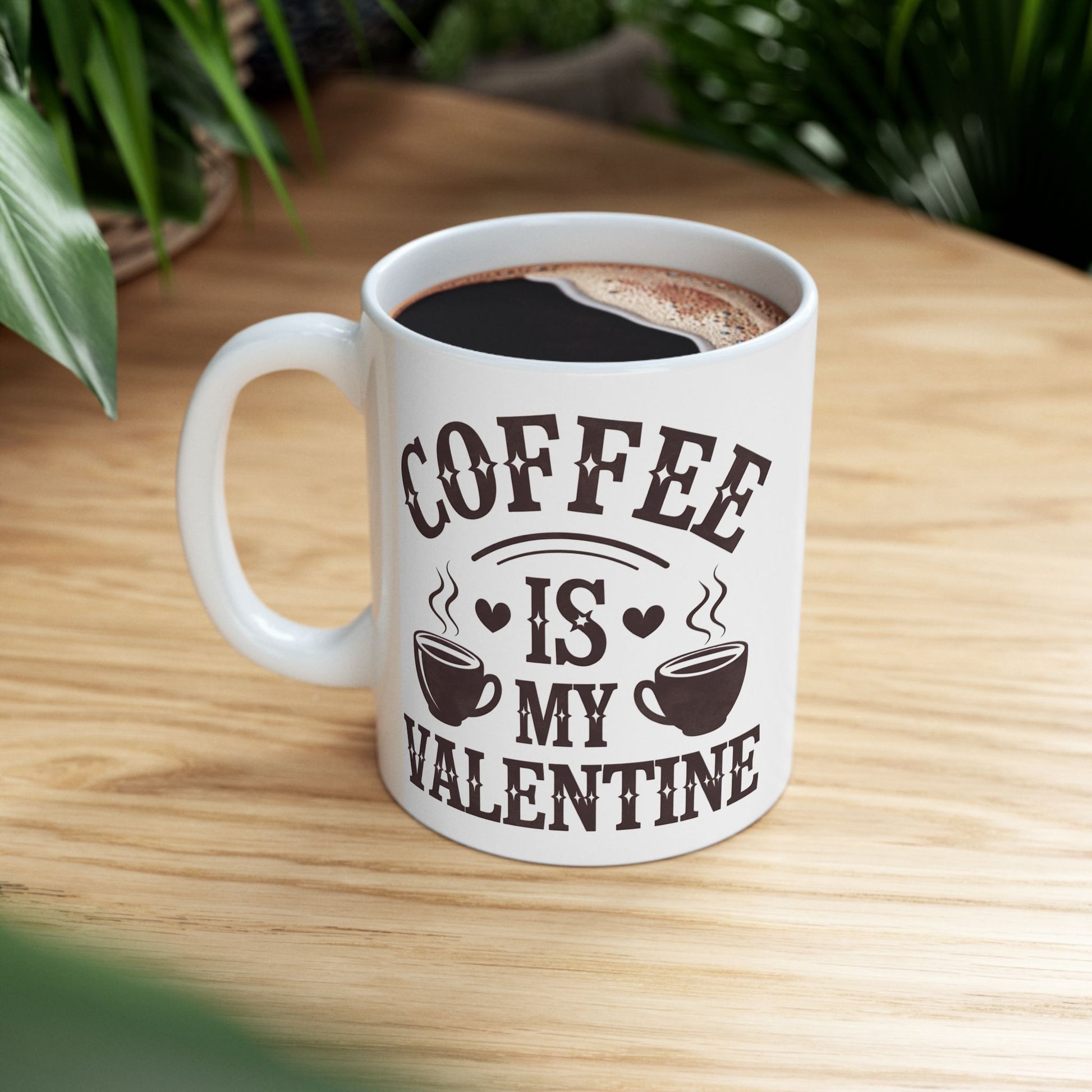 White mug with 'Coffee is my Valentine' text on a wooden table