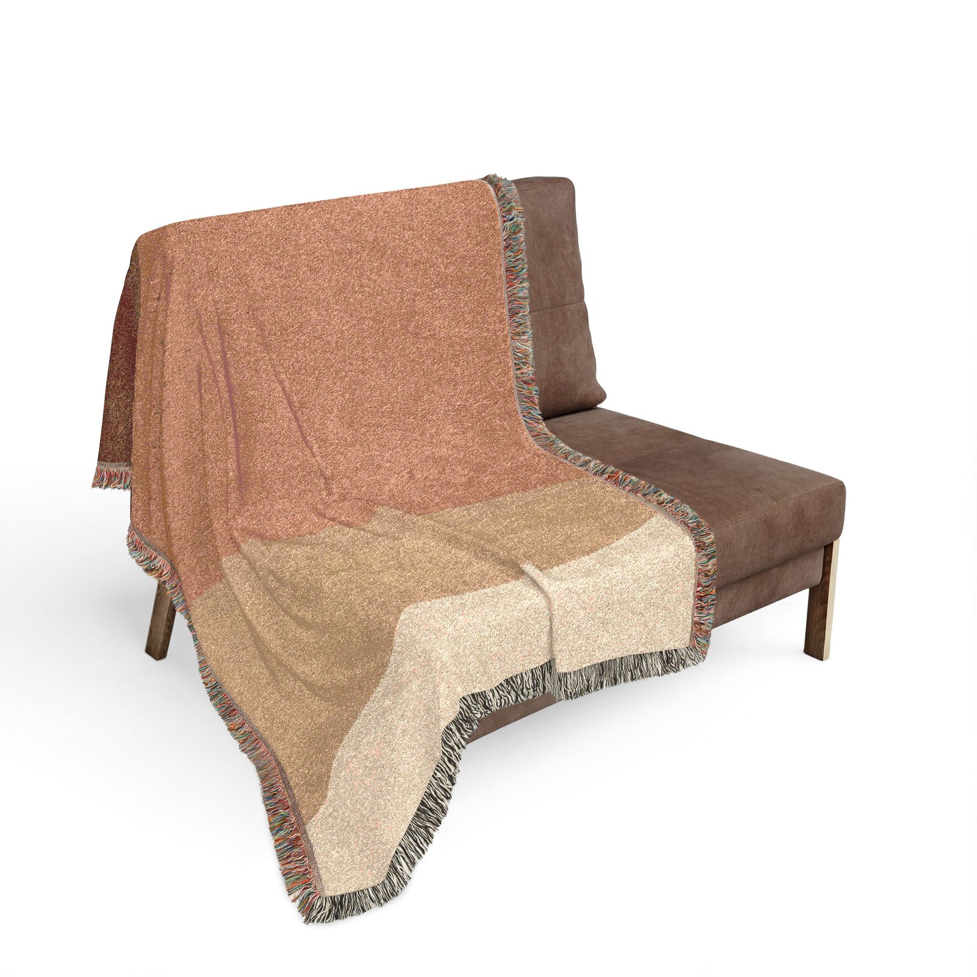 Brown and beige patterned throw blanket draped over a brown chair on a white background