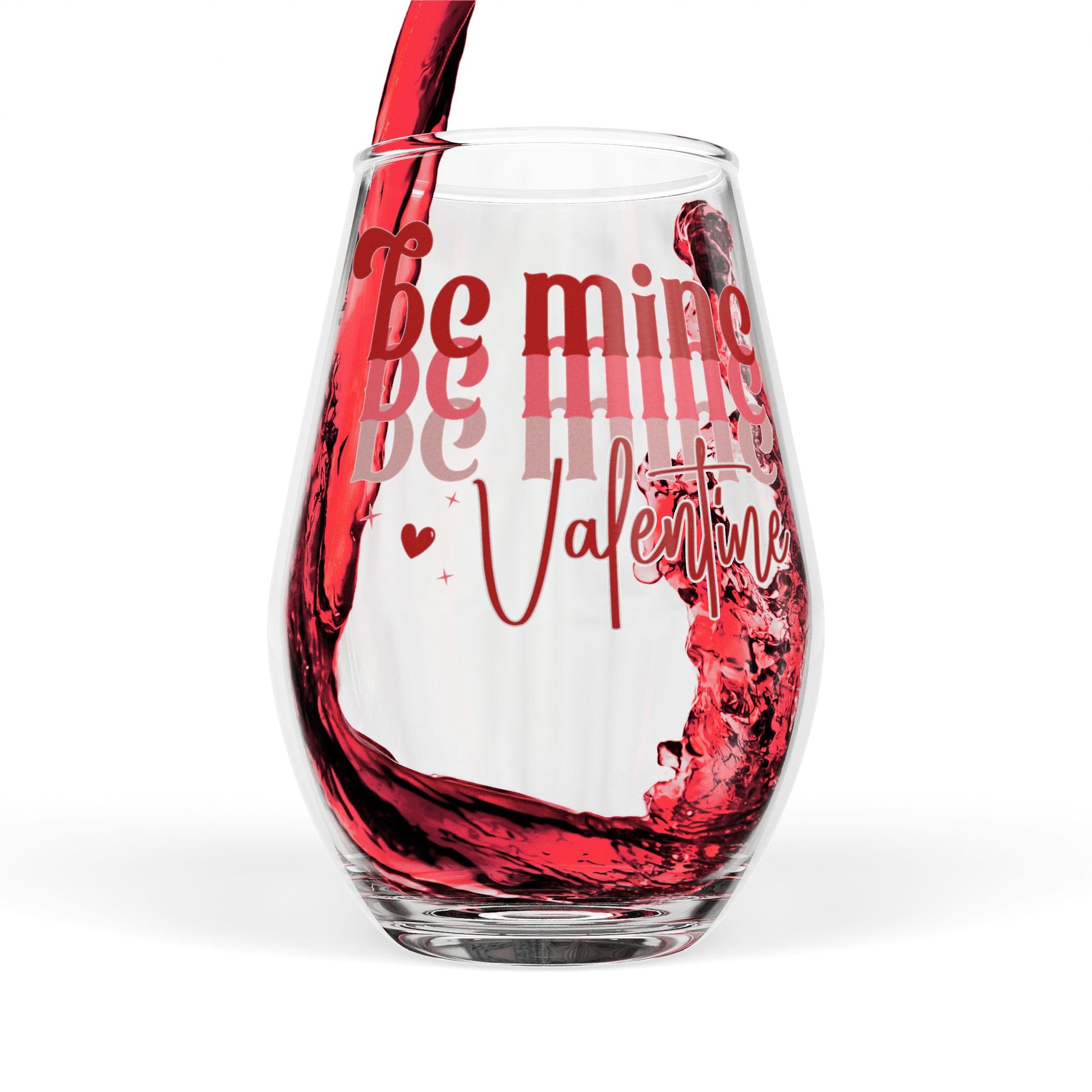 Clear wine glass with red wine pouring into it, featuring the text 'Be mine Valentine' on a white background.