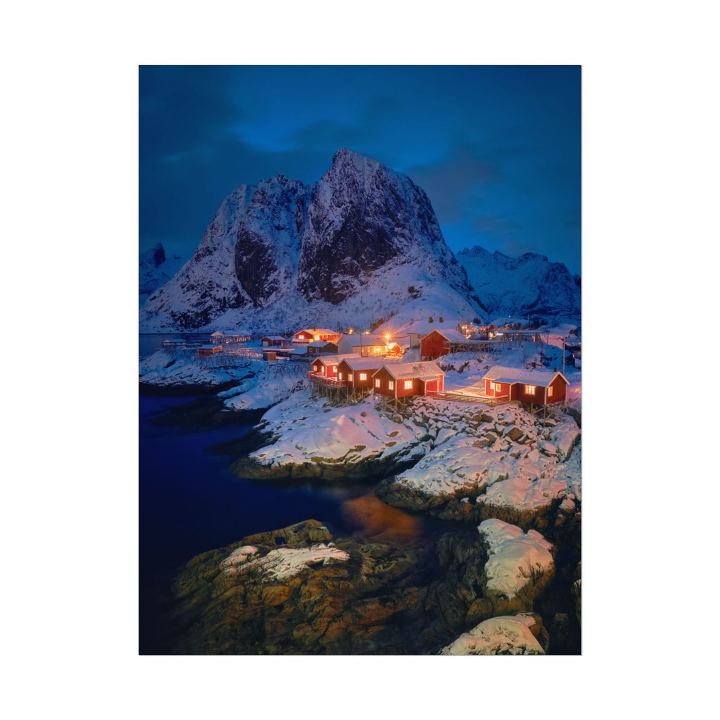 Snowy mountain landscape with illuminated buildings at night