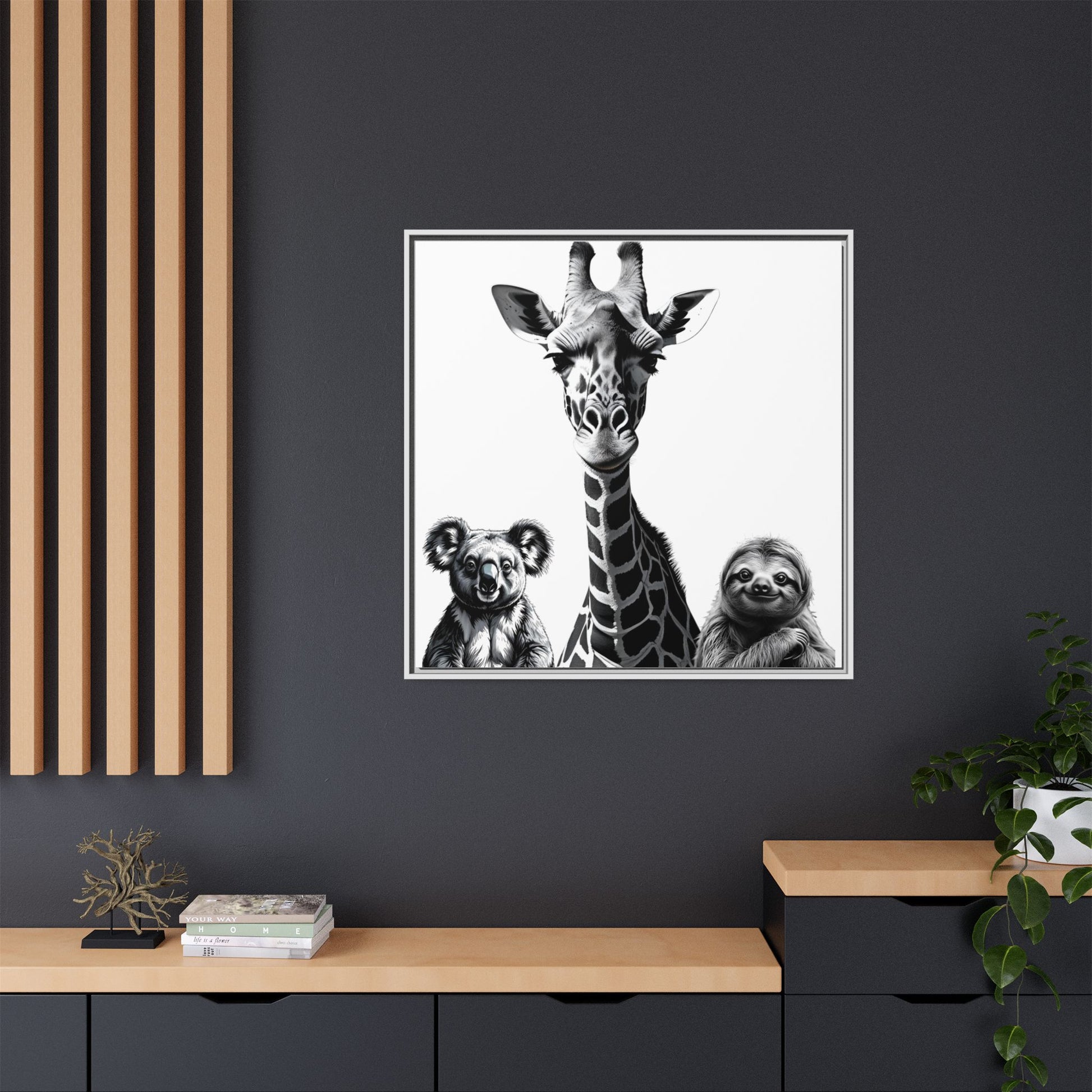 Framed artwork of a giraffe, koala, and sloth on a dark wall with wooden shelves.