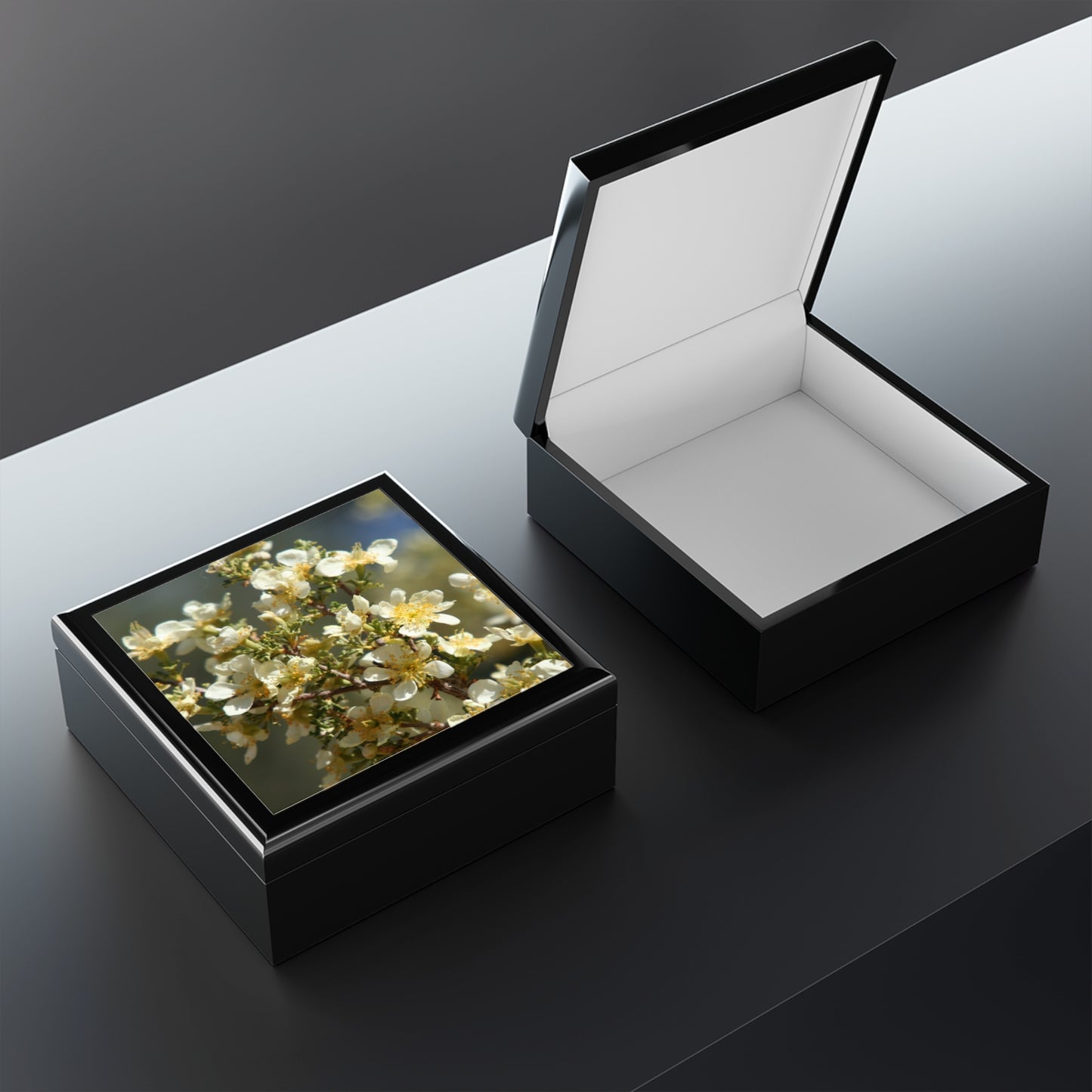 Black jewelry box with a floral design on a reflective surface