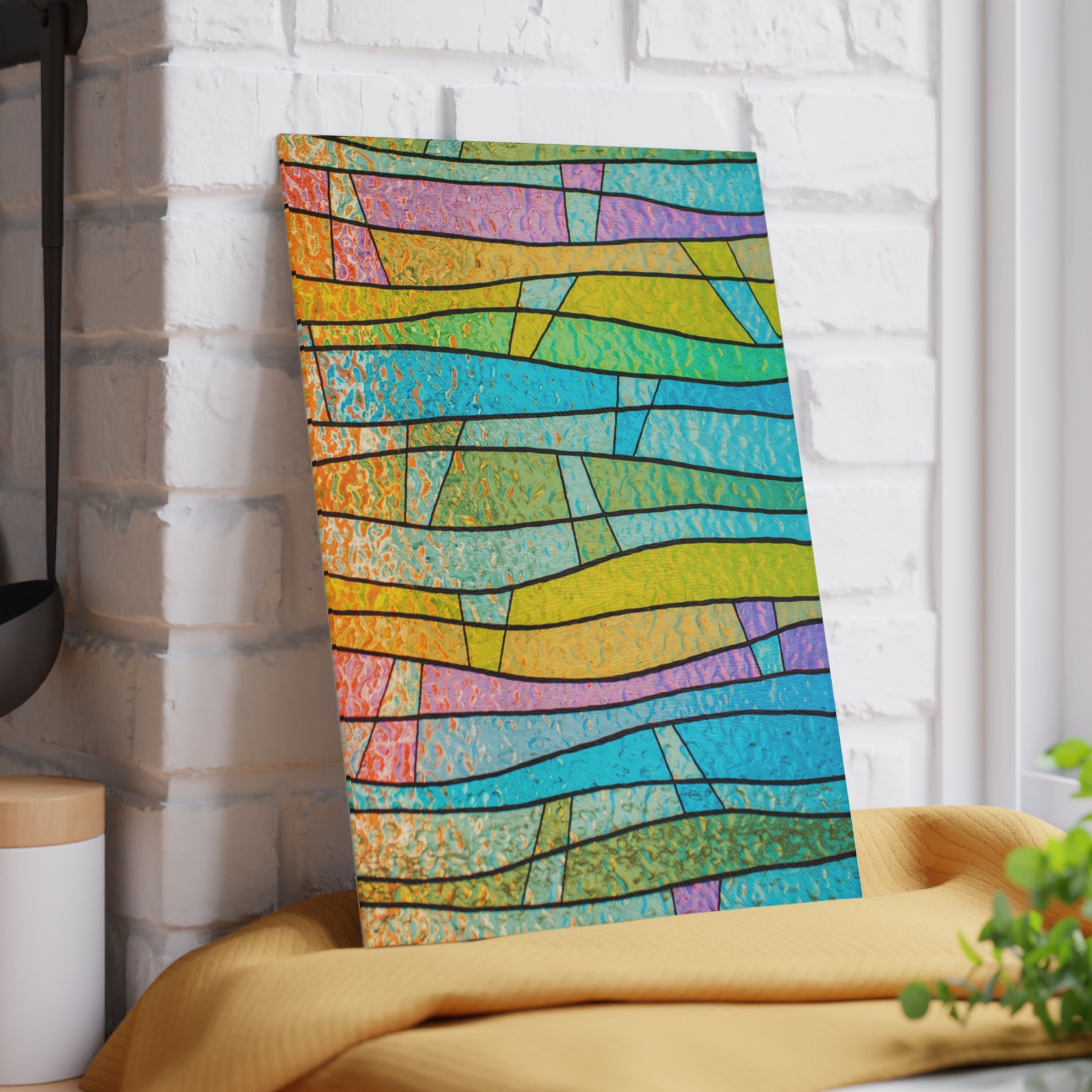 Colorful abstract patterned towel hanging on a white brick wall.