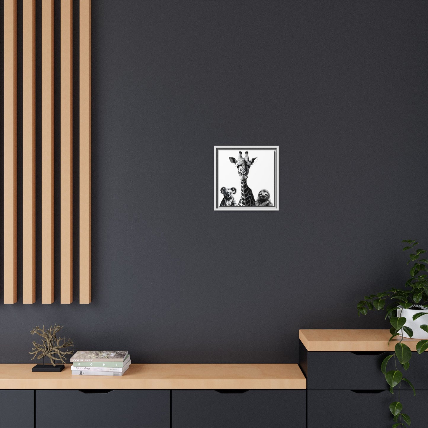 Framed artwork of a giraffe and two dogs on a dark wall with wooden furniture and decor.