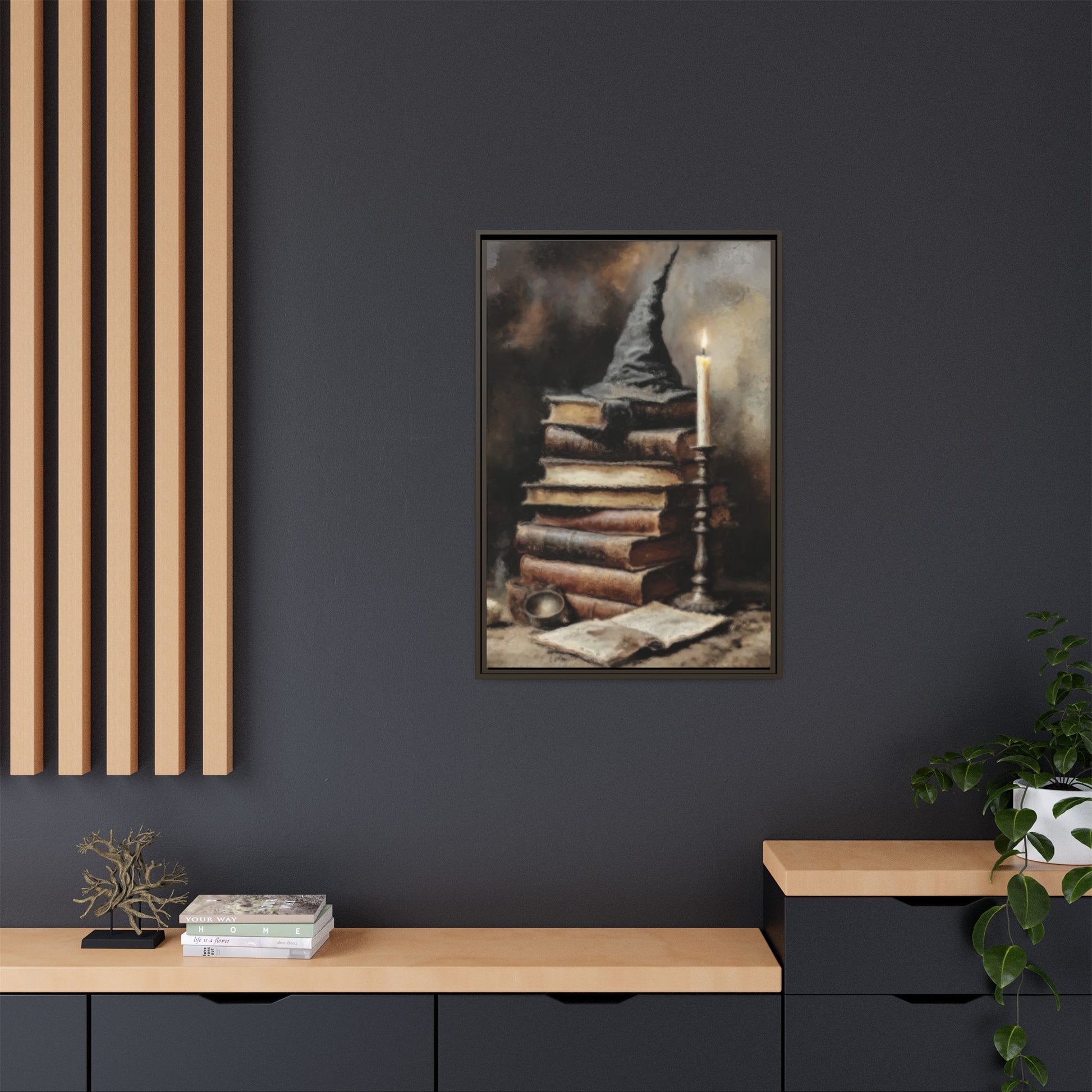Framed artwork of books and a candle on a dark wall above a wooden shelf.