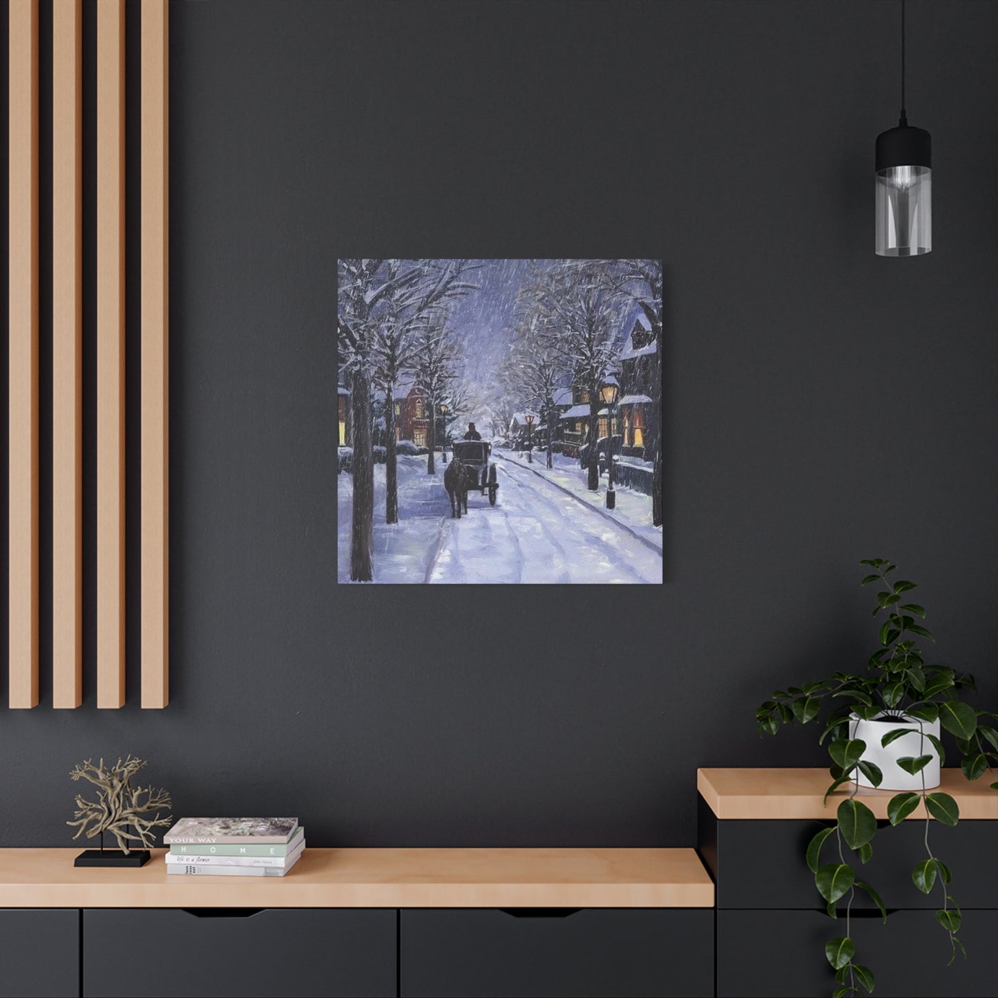 Framed artwork of a snowy street scene on a dark wall above a wooden console table.