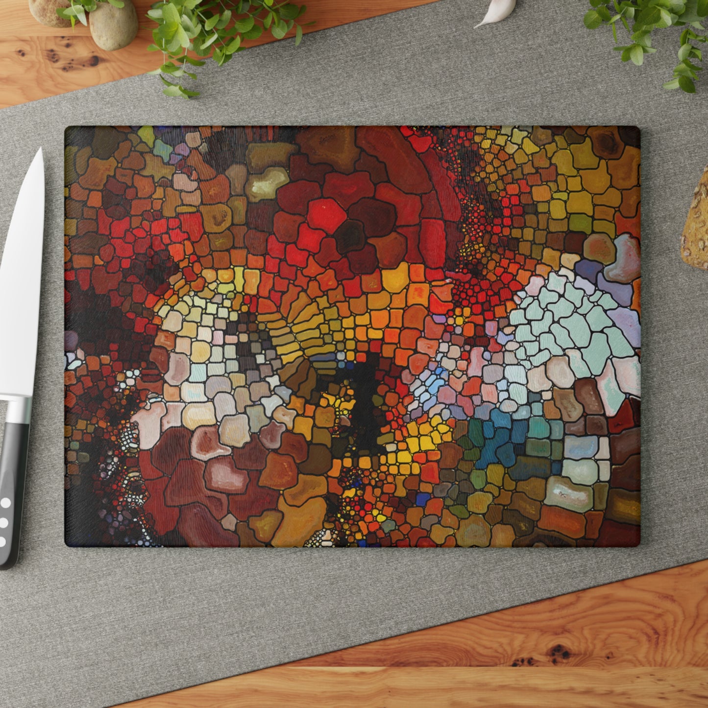 Colorful mosaic cutting board on a gray surface with a knife