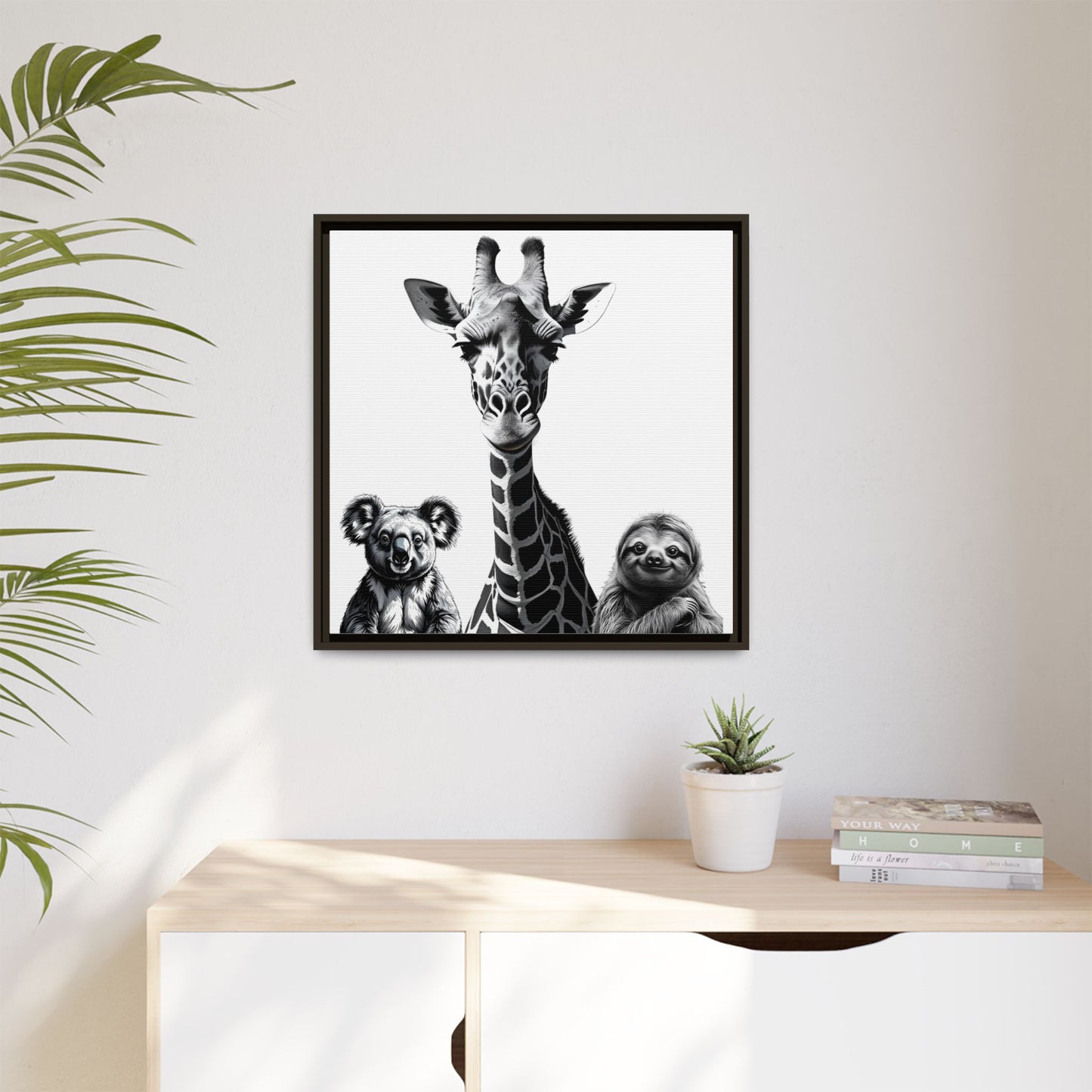 Framed artwork with a giraffe, koala, and sloth on a wall above a desk.
