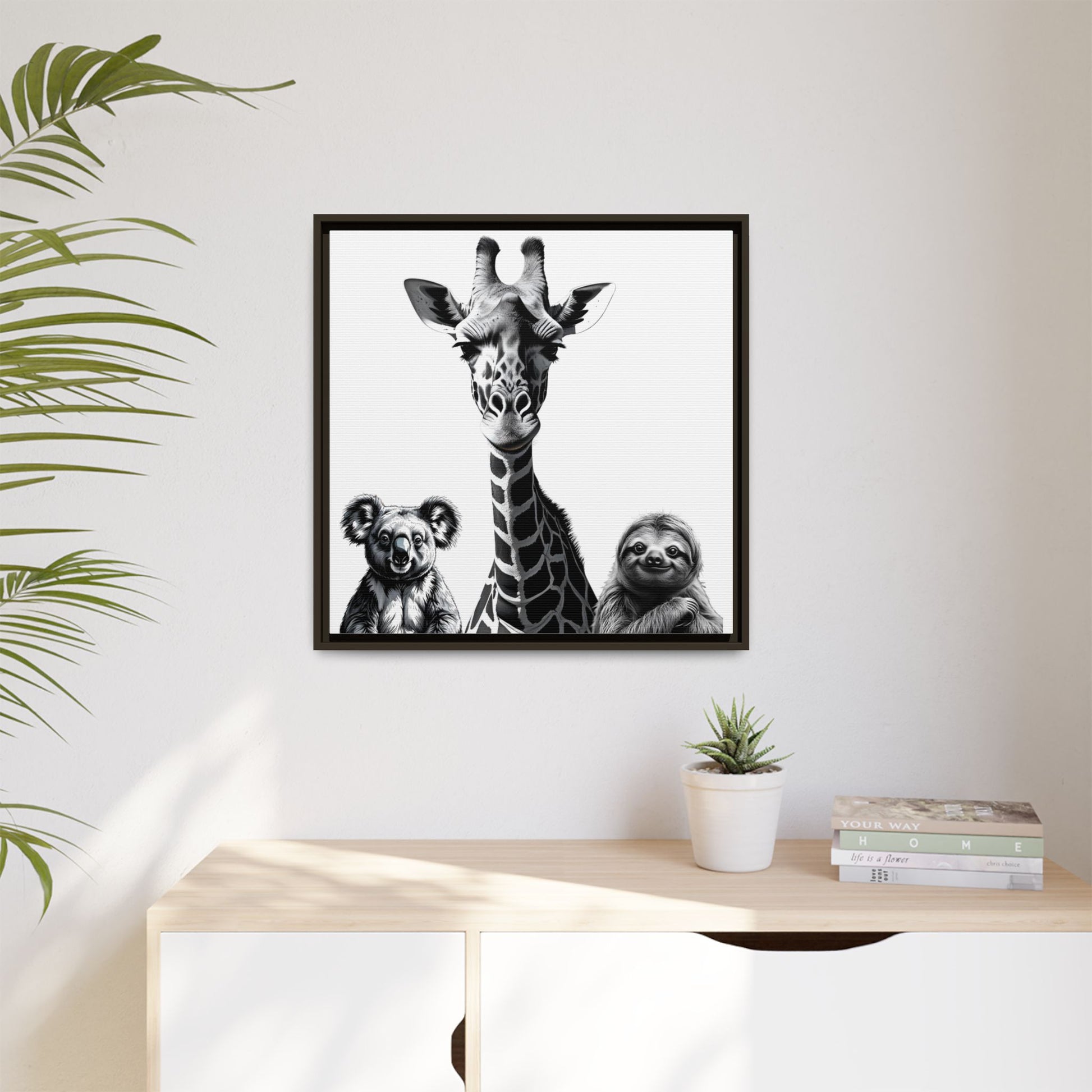 Framed artwork with a giraffe, koala, and sloth on a wall above a desk.