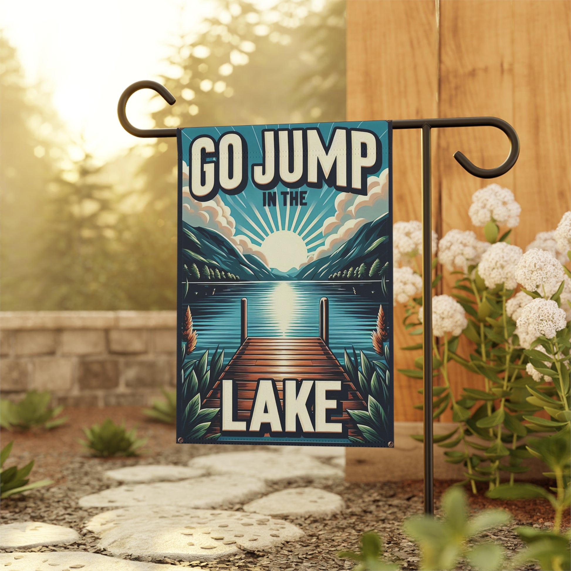 Decorative garden flag with 'GO JUMP IN THE LAKE' text and a lake scene, hanging outdoors.