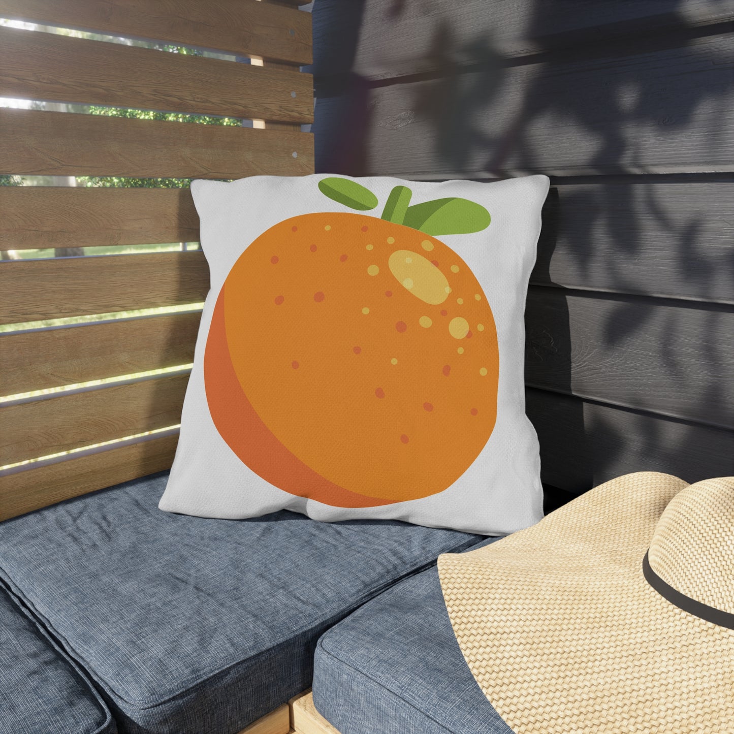 Pillow with an orange design on a bench outdoors