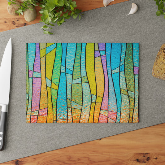 Colorful abstract design on a cutting board with a knife and plant in the background.