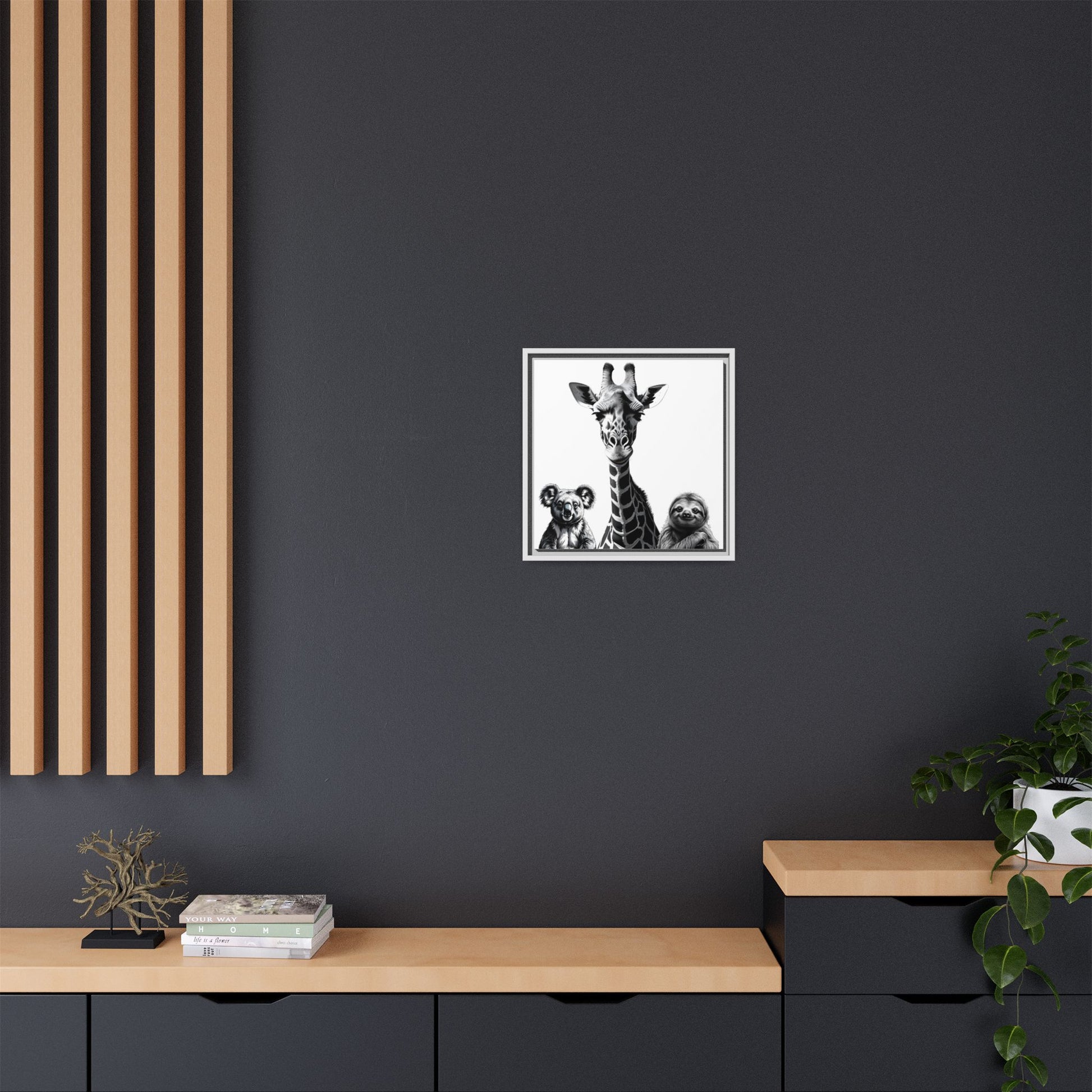 Framed artwork of a giraffe and two bears on a dark wall above a wooden shelf.